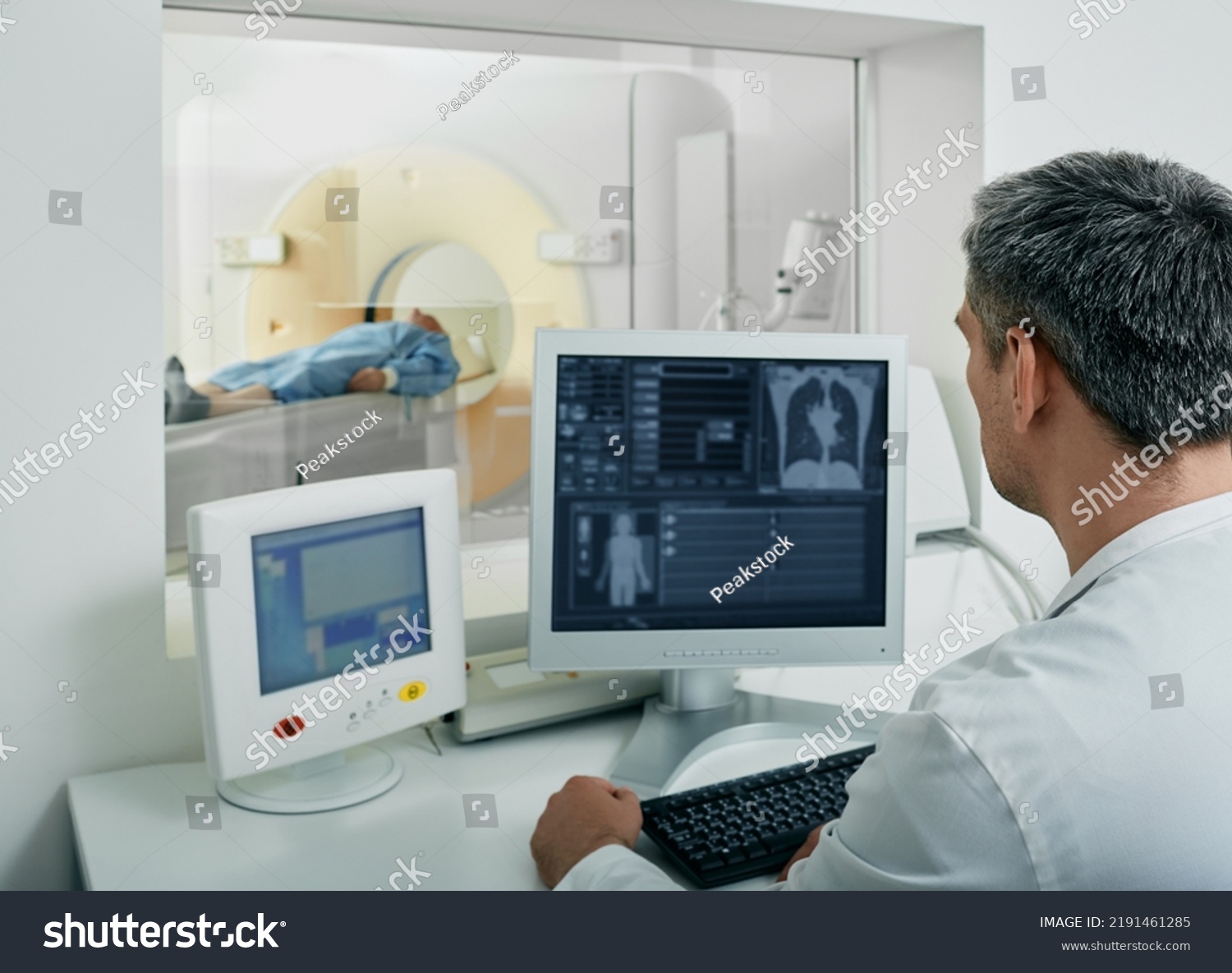 Doctor radiologist running CT scan for patient's body lungs from control room. Computed Tomography #2191461285