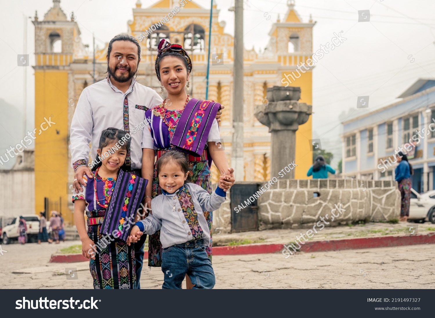 Latin family smiling looking at the camera with their two children.
Hispanic family in front of a church in a rural area. #2191497327