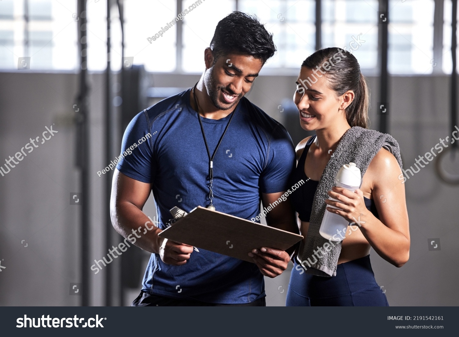 Gym subscription, personal trainer and happy client talking and ready to fill in a membership form. Fitness coach discussing training, workout plan and progress in a health and wellness facility #2191542161