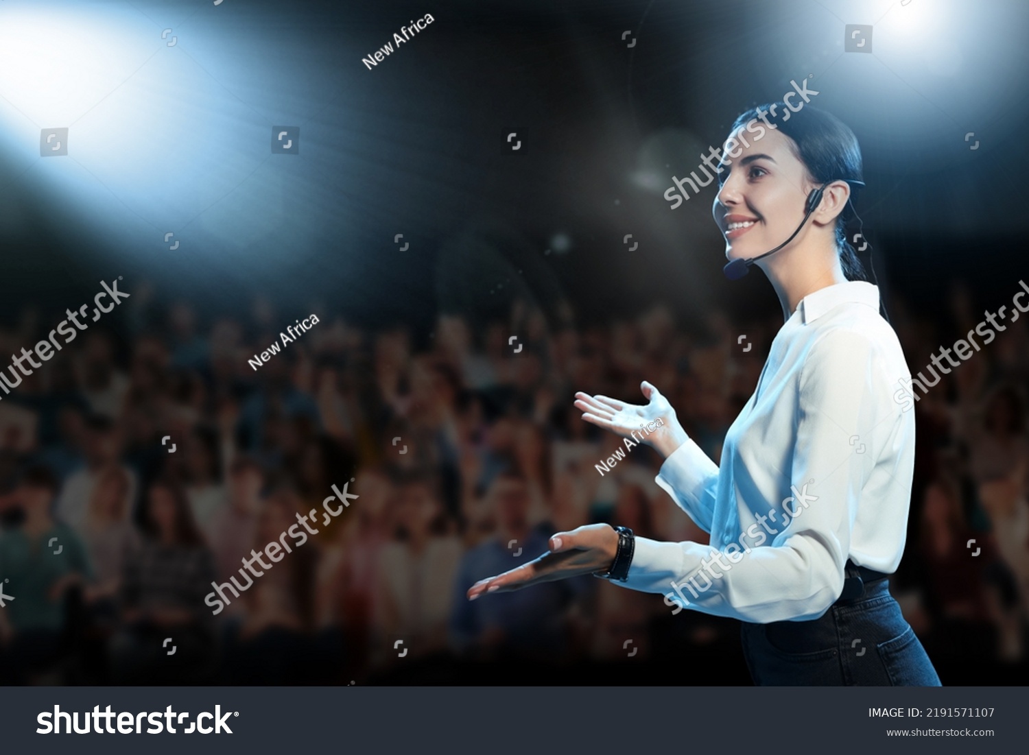 Motivational speaker with headset performing on stage #2191571107