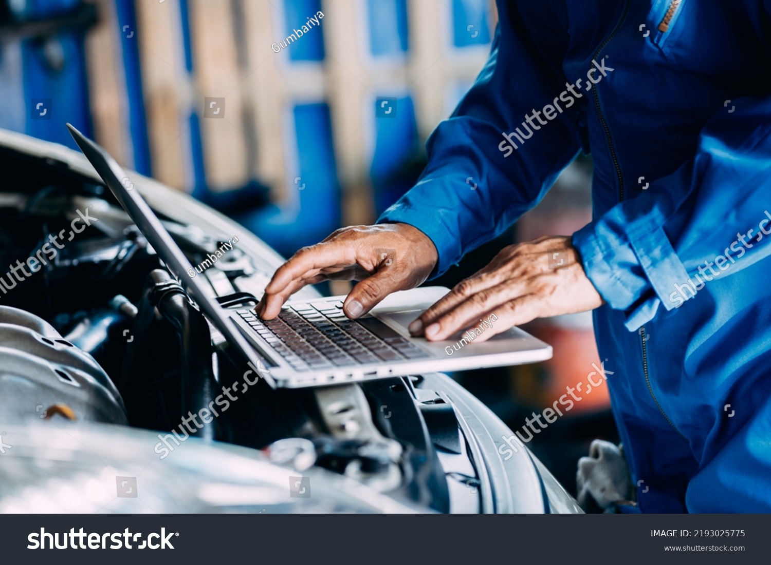Automotive mechanic repairman using laptop computer and checking engine in the engine room, check the mileage of the car, oil change, auto maintenance service concept #2193025775