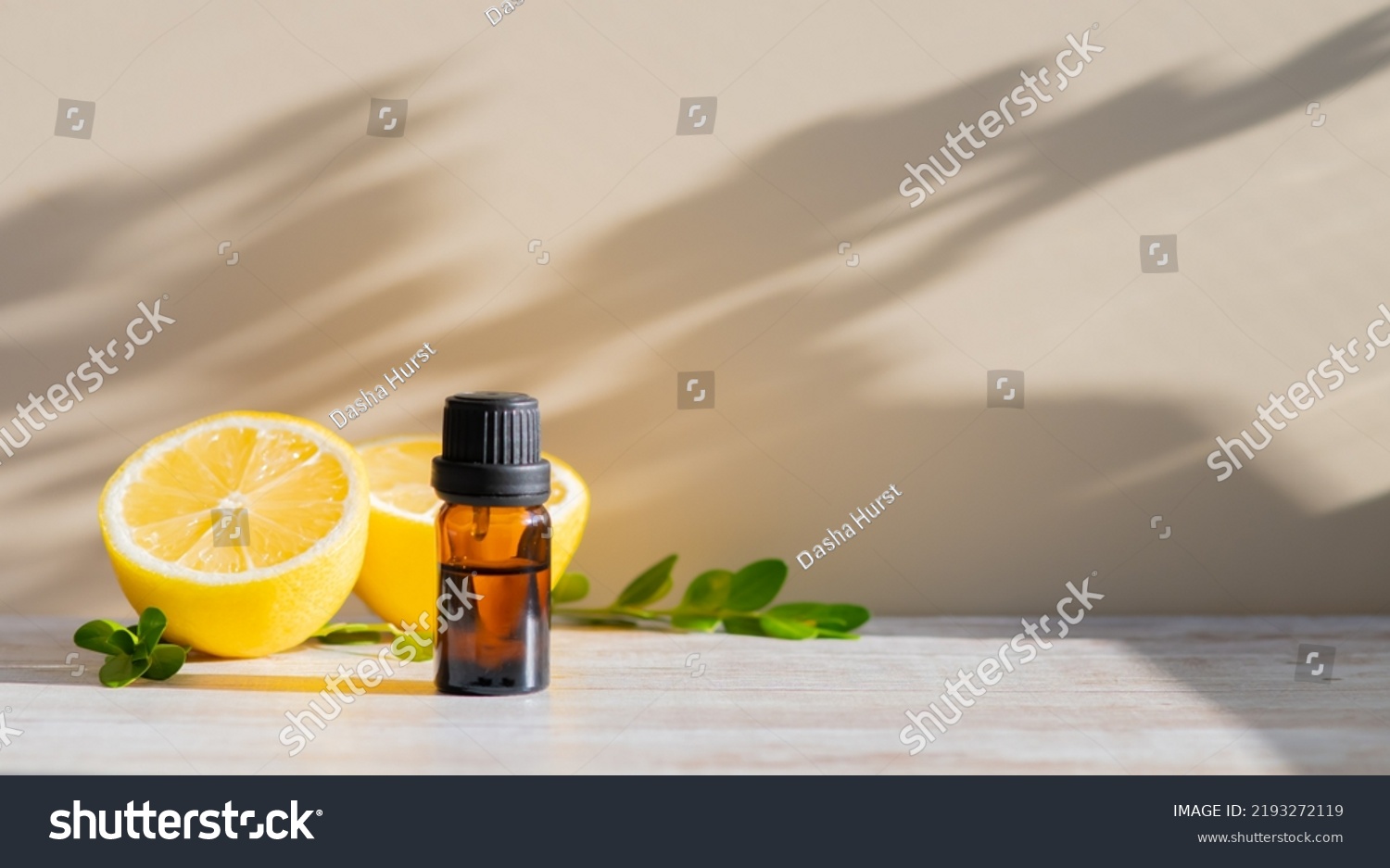 Essential oil in brown bottle and cut lemon on a background #2193272119