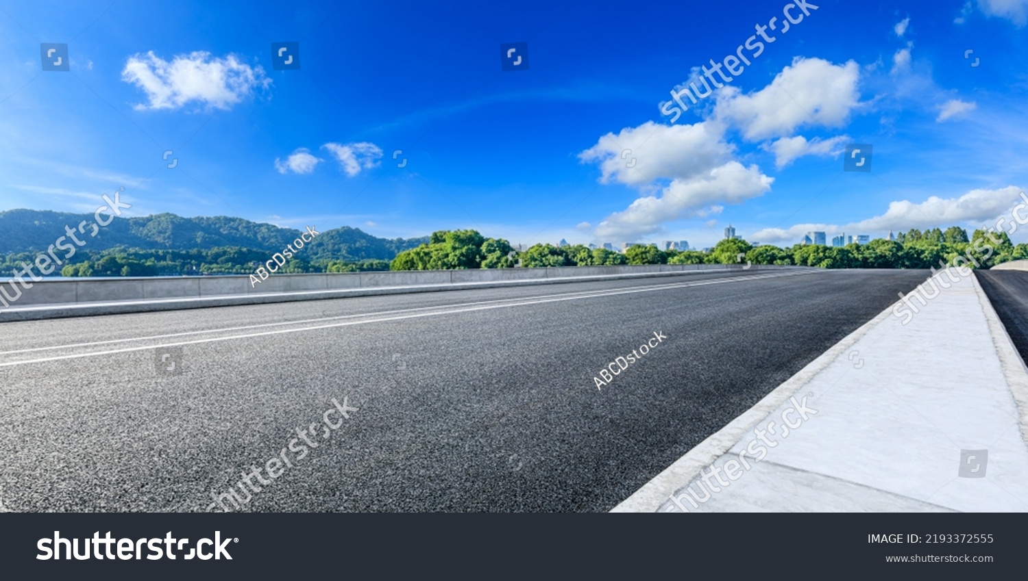 Asphalt road and mountain with city skyline scenery #2193372555