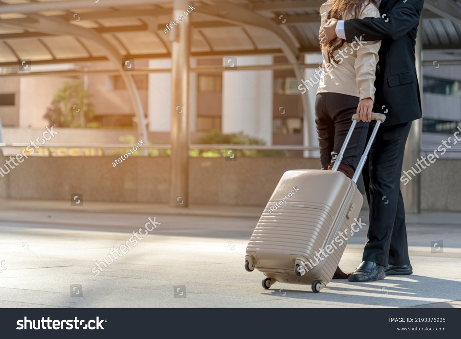 Businesspeople couple lover walking with luggage in business trip. Honeymoon business trip hug together on boarding arrival terminal. Business travel trip holding suitcase at airport couple traveller #2193376925