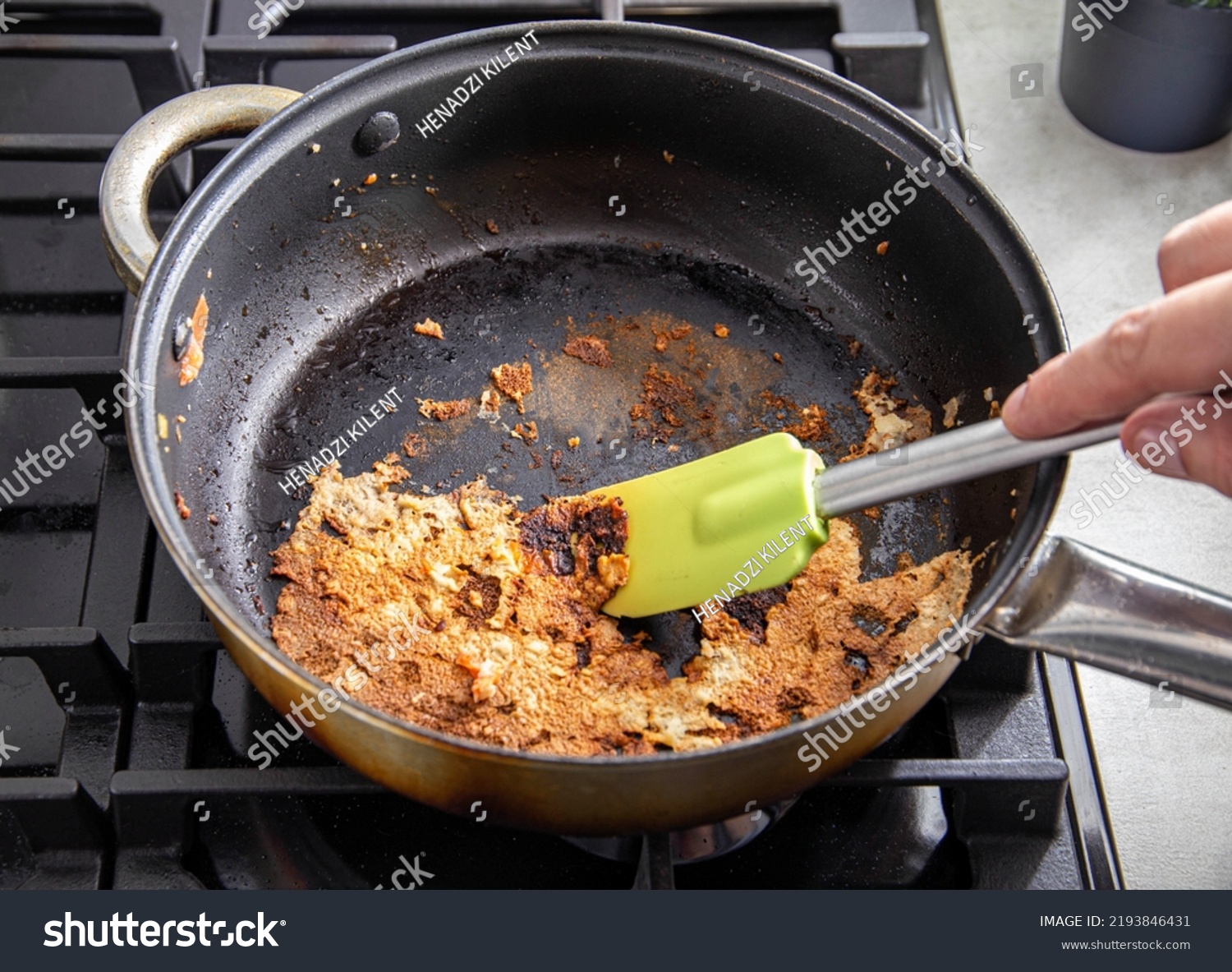 A spatula for stirring food picks off burnt food in a pan. Poor quality Teflon coated pans. #2193846431