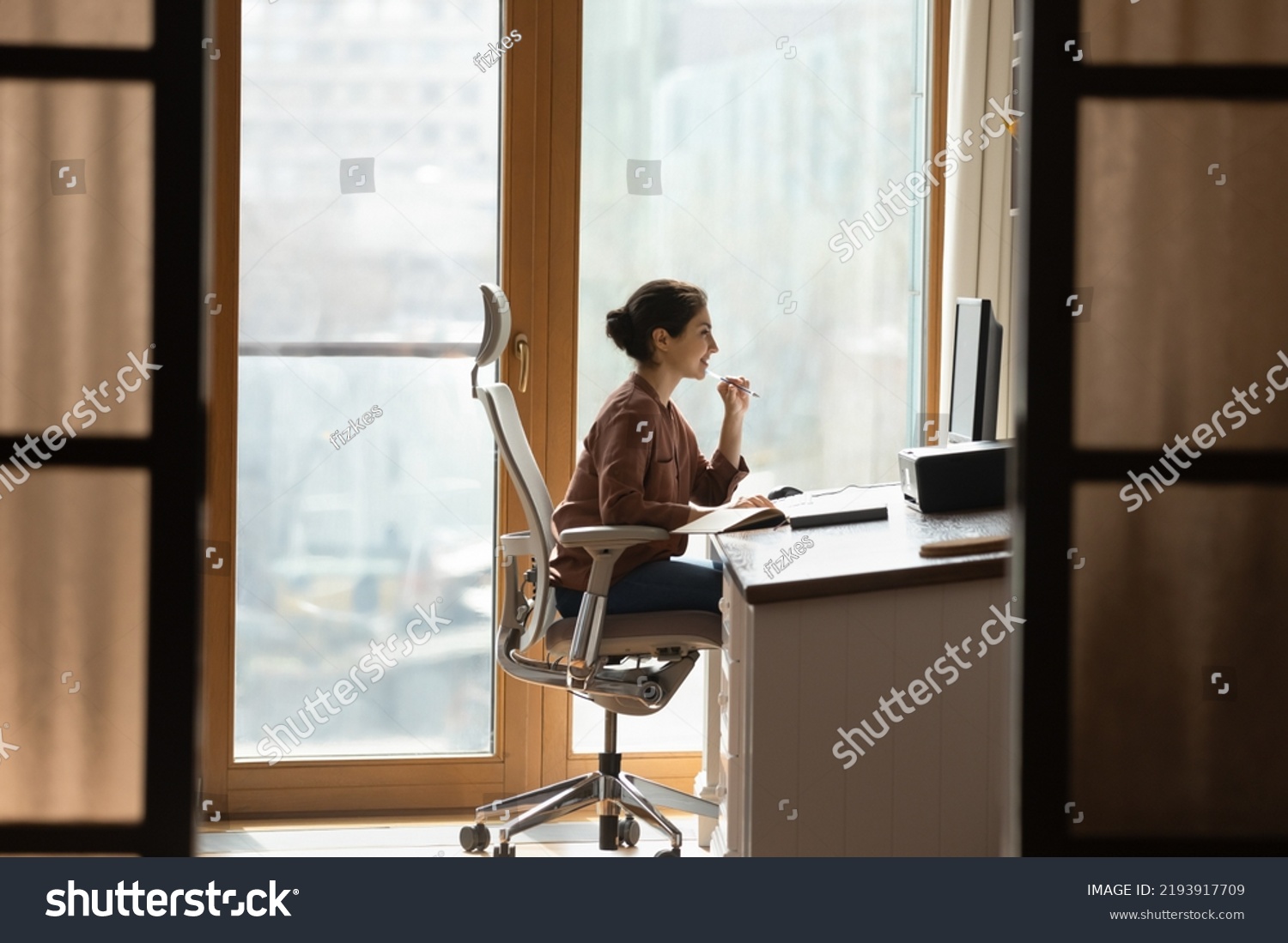 Working at modern home office. Young female architect interior designer sit at desk on ergonomic chair doing job project on desktop pc. Millennial indian woman study at domestic workplace #2193917709
