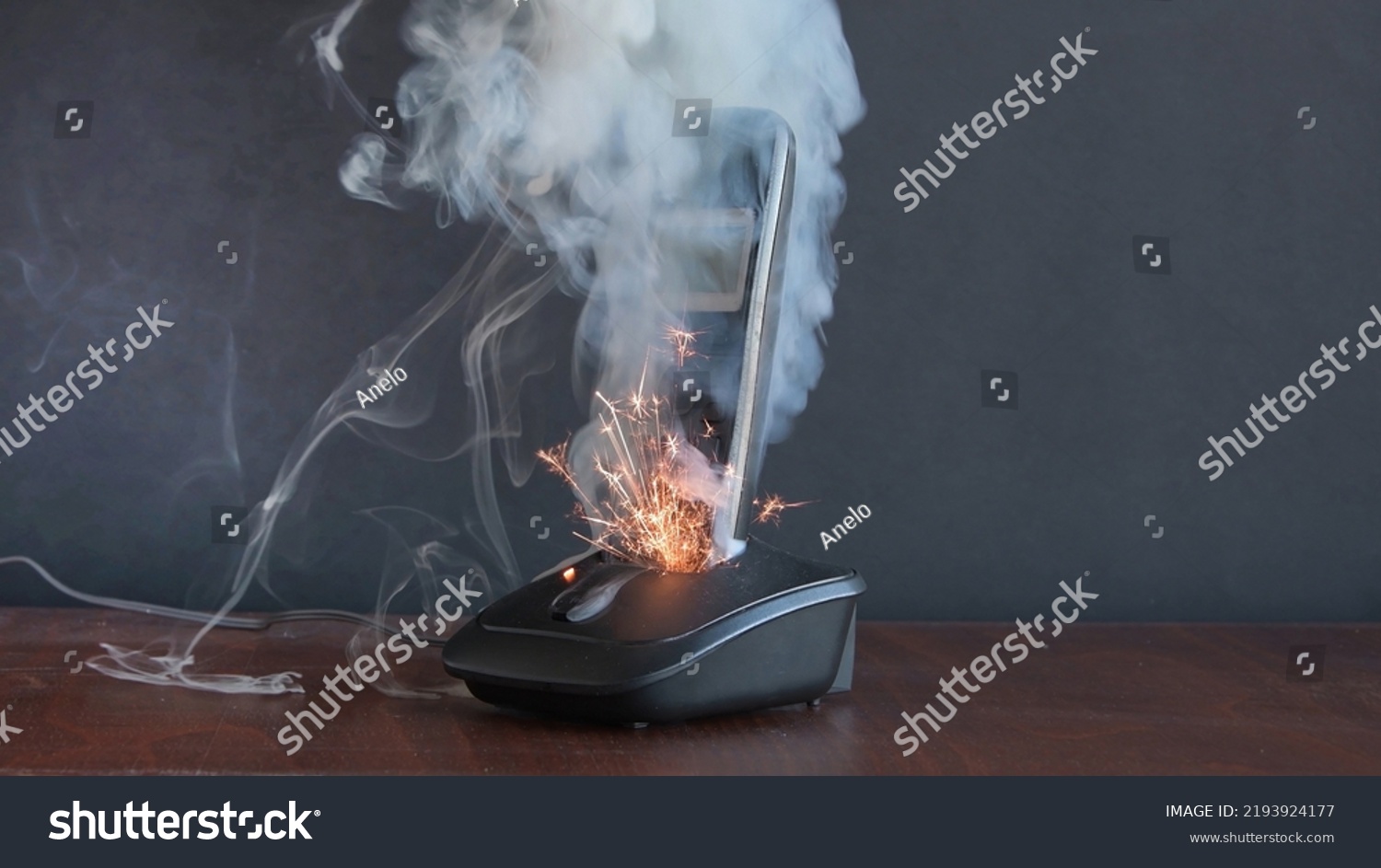 the radiotelephone smokes and burns, sparks fly, a short circuit in household electrical appliances and household appliances. Concept: house fire and electrical wiring fires. #2193924177