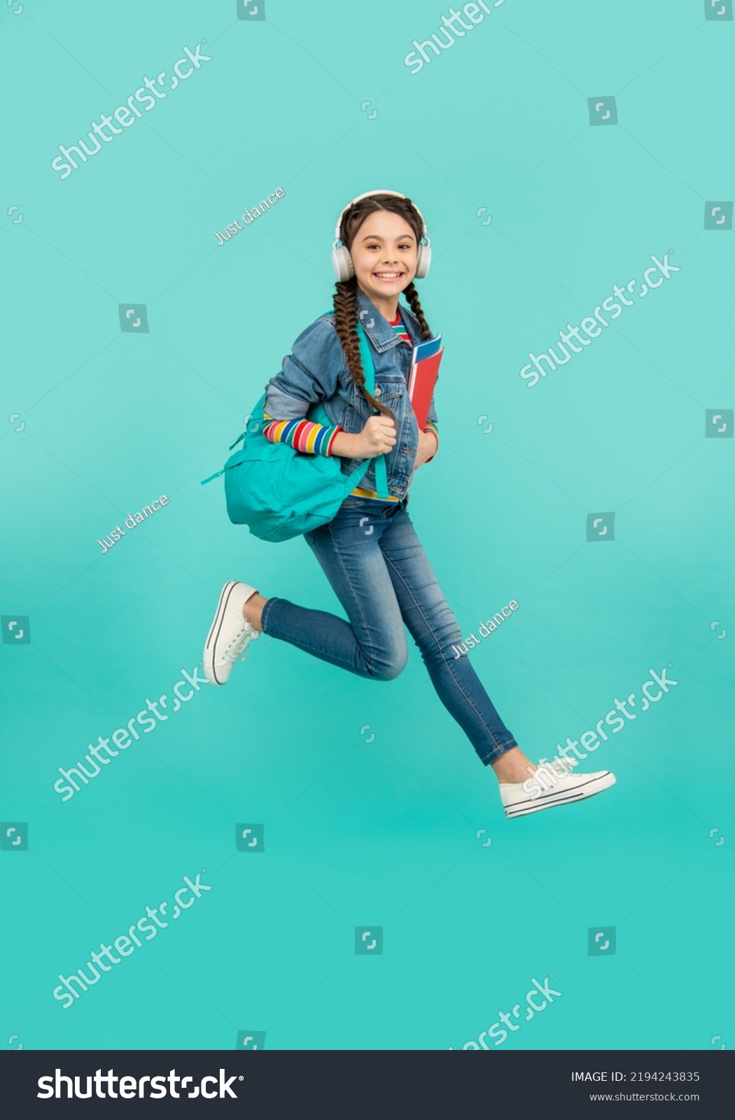 Happy girl jumping blue background, education. - Royalty Free Stock ...