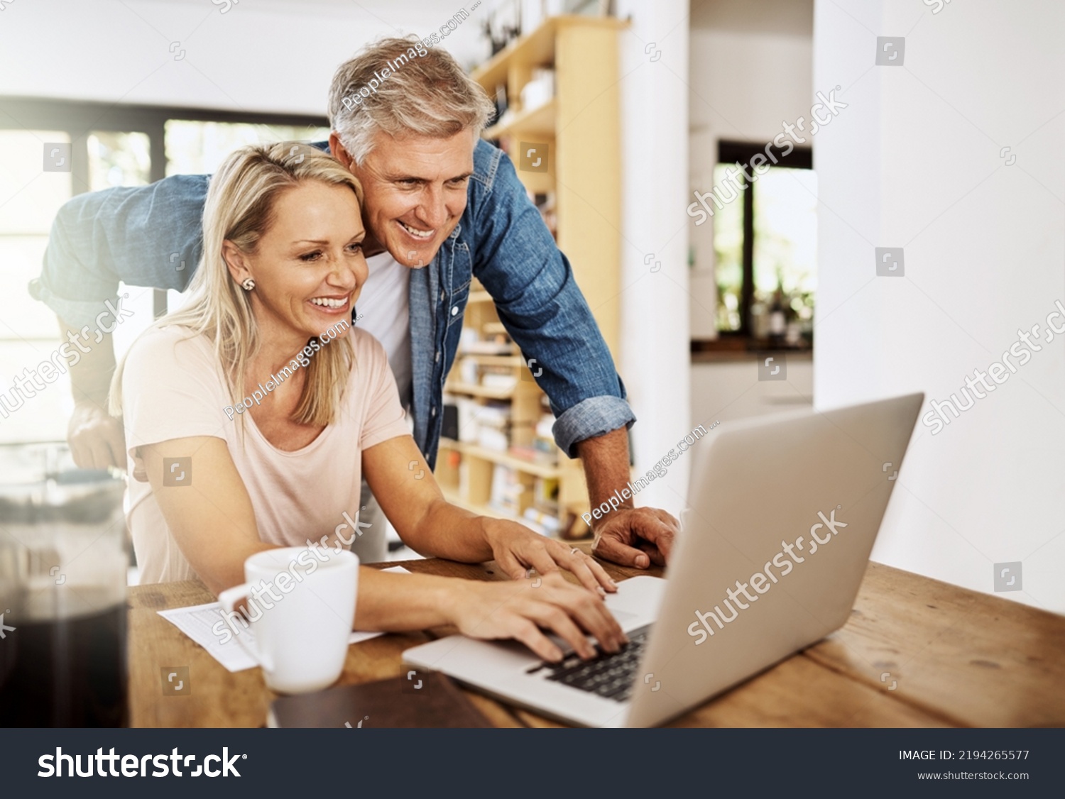 Happy, smiling and mature couple using a laptop together at home. Charming husband assisting wife with online work on the internet. Cheerful Middle aged partners working as a team on social media. #2194265577