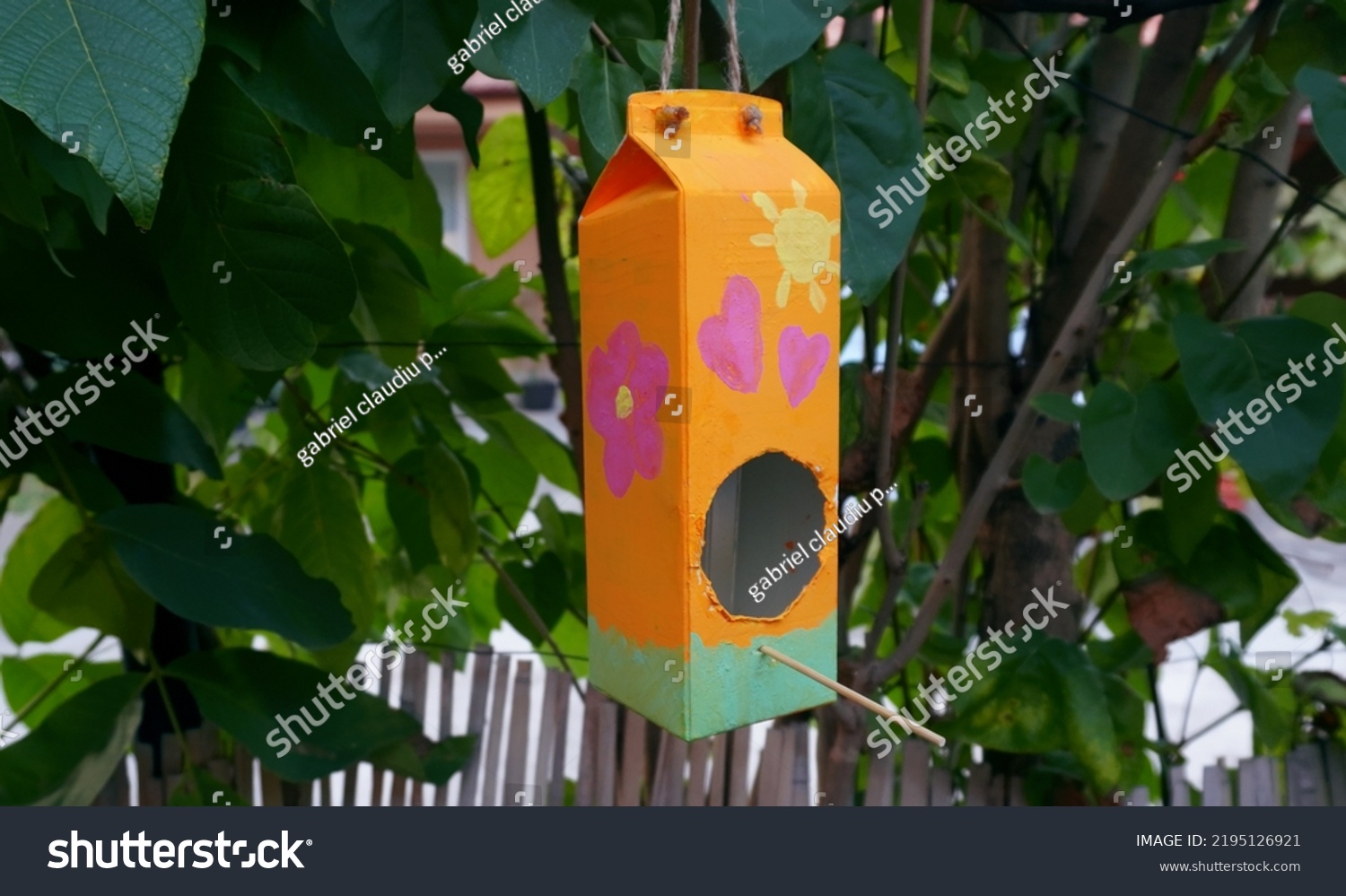 Homemade Bird Feeder in a tree. Milk Carton Bird House in a tree      #2195126921