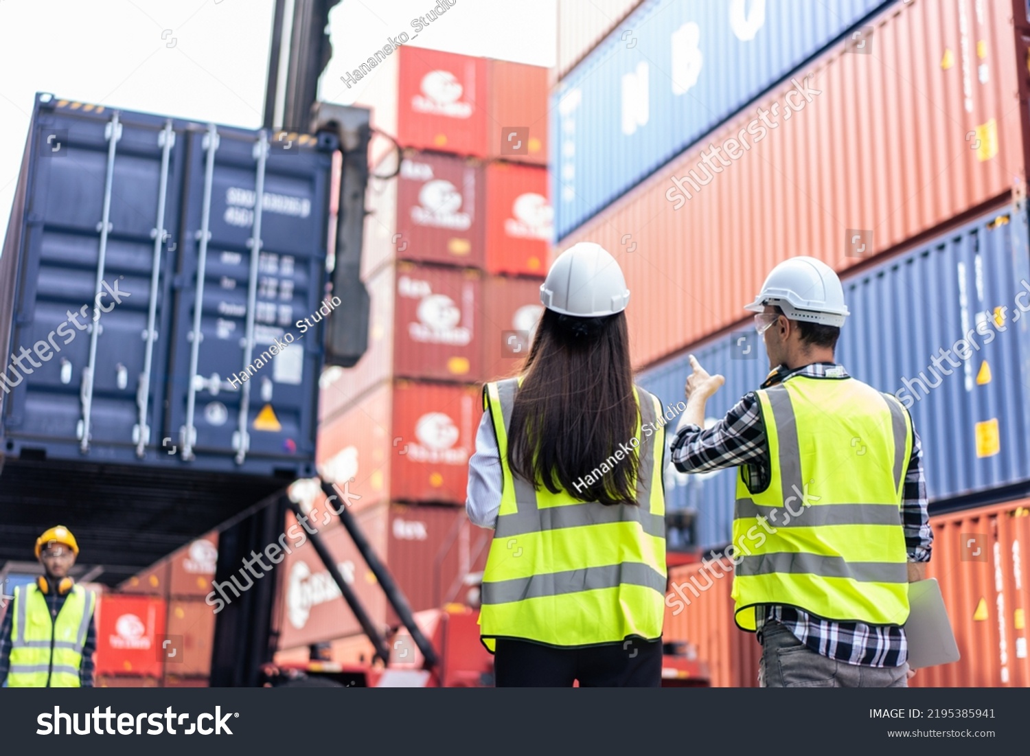 Caucasian business man and woman worker working in container terminal. Attractive engineer people processes orders and product at warehouse logistic in cargo freight ship for import export in harbor.
 #2195385941