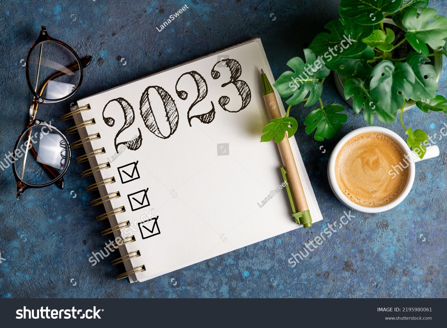 New year resolutions 2023 on desk. 2023 resolutions list with notebook, coffee cup on table. Goals, resolutions, plan, action, checklist concept. New Year 2023 template, copy space #2195980061