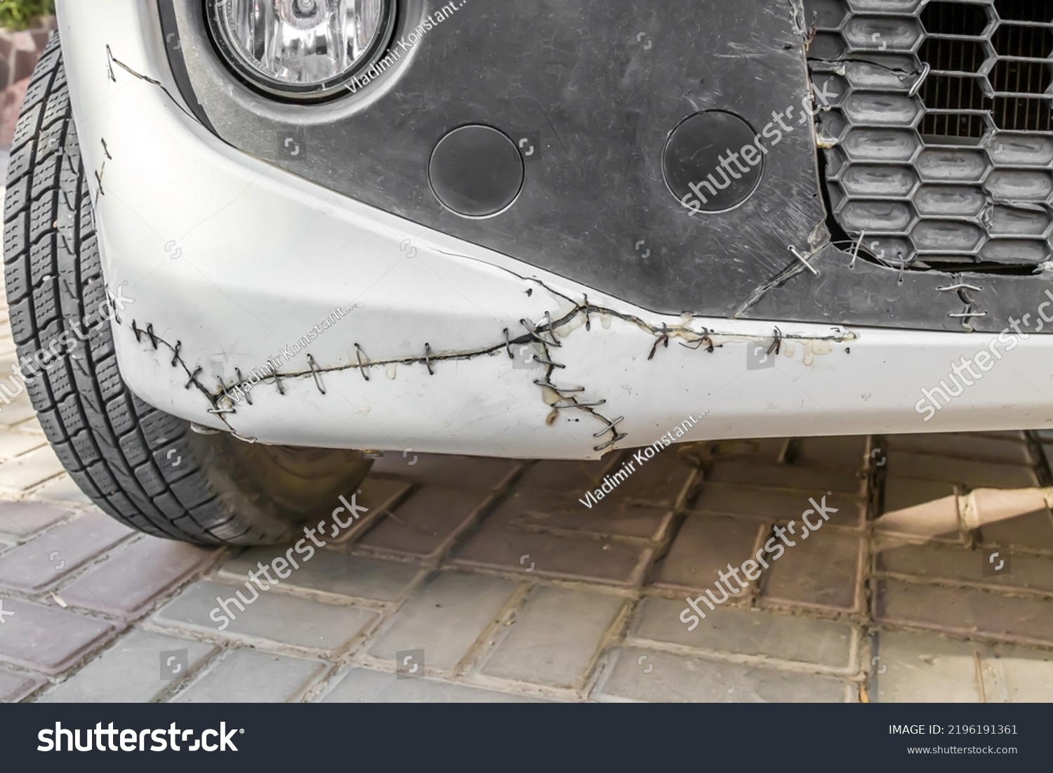 Metal rivets on a cracked car bumper.Old broken car bumper with metal wire #2196191361