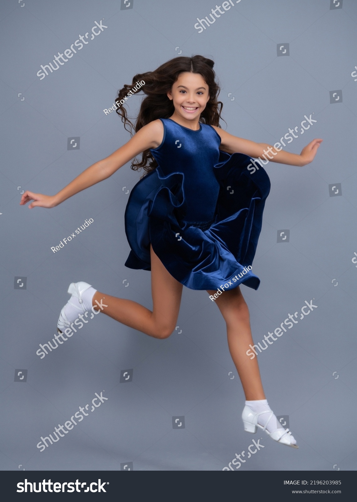 Full length teenager with movement dress. Young teen child with flowing skirt. Teen girl fluttering dress in motion, isolated on gray. #2196203985