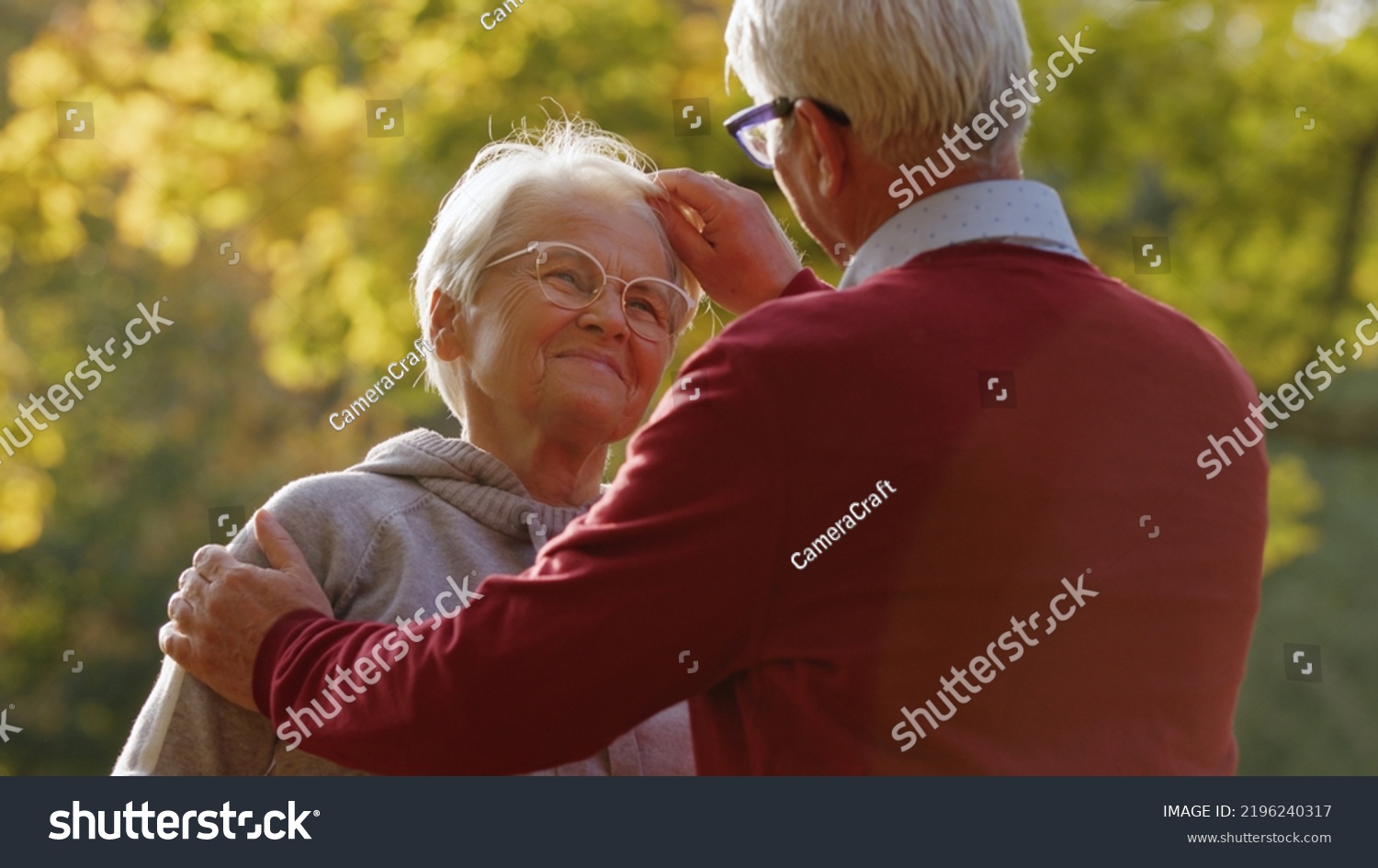 Joy of retirement. Older senior caucasian heterosexual couple. Man gently touches his beloved wife's gray hair and looks her in the eye. High quality photo #2196240317