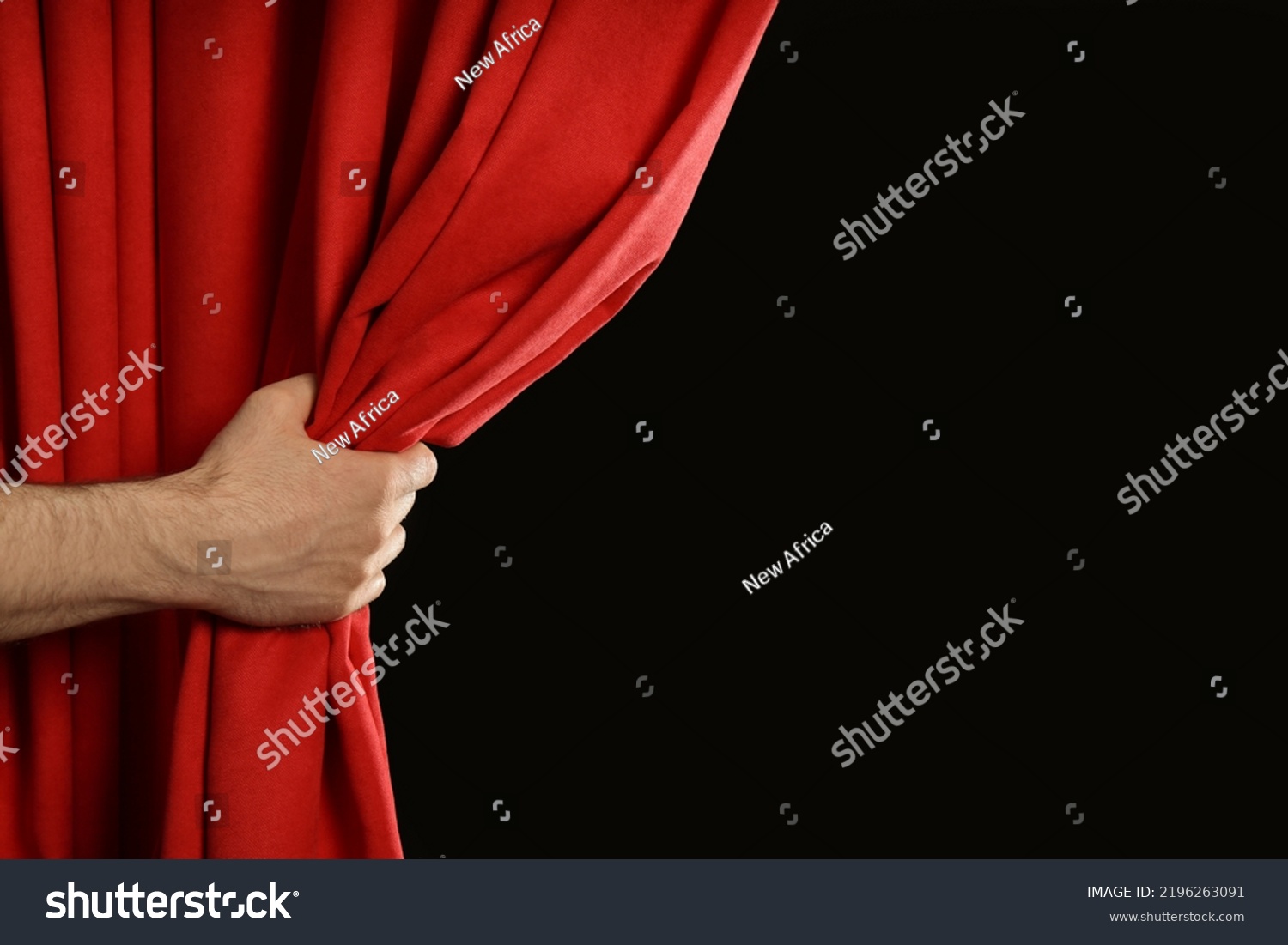 Man opening red front curtains on black background, closeup. Space for text #2196263091
