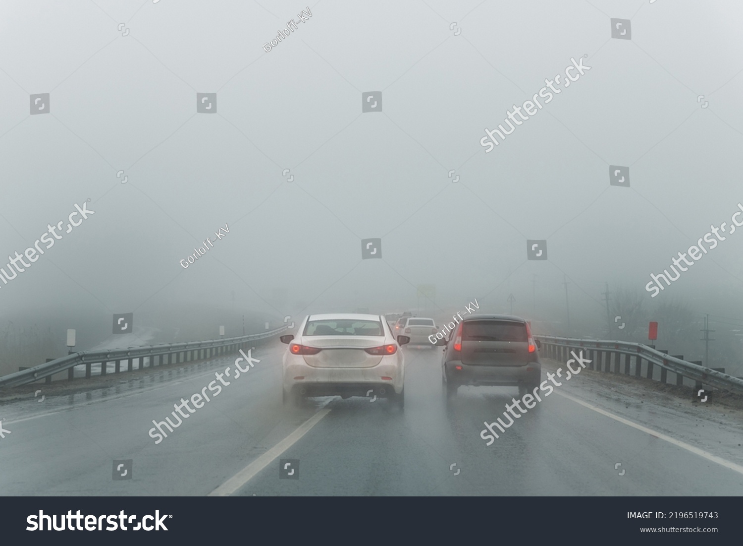 Car overtake rules violation crossing double lane. traffic on foggy misty rainy highway intercity road low poor visibility cold winter autumn day. Seasonal bad rainy weather accident danger warning #2196519743