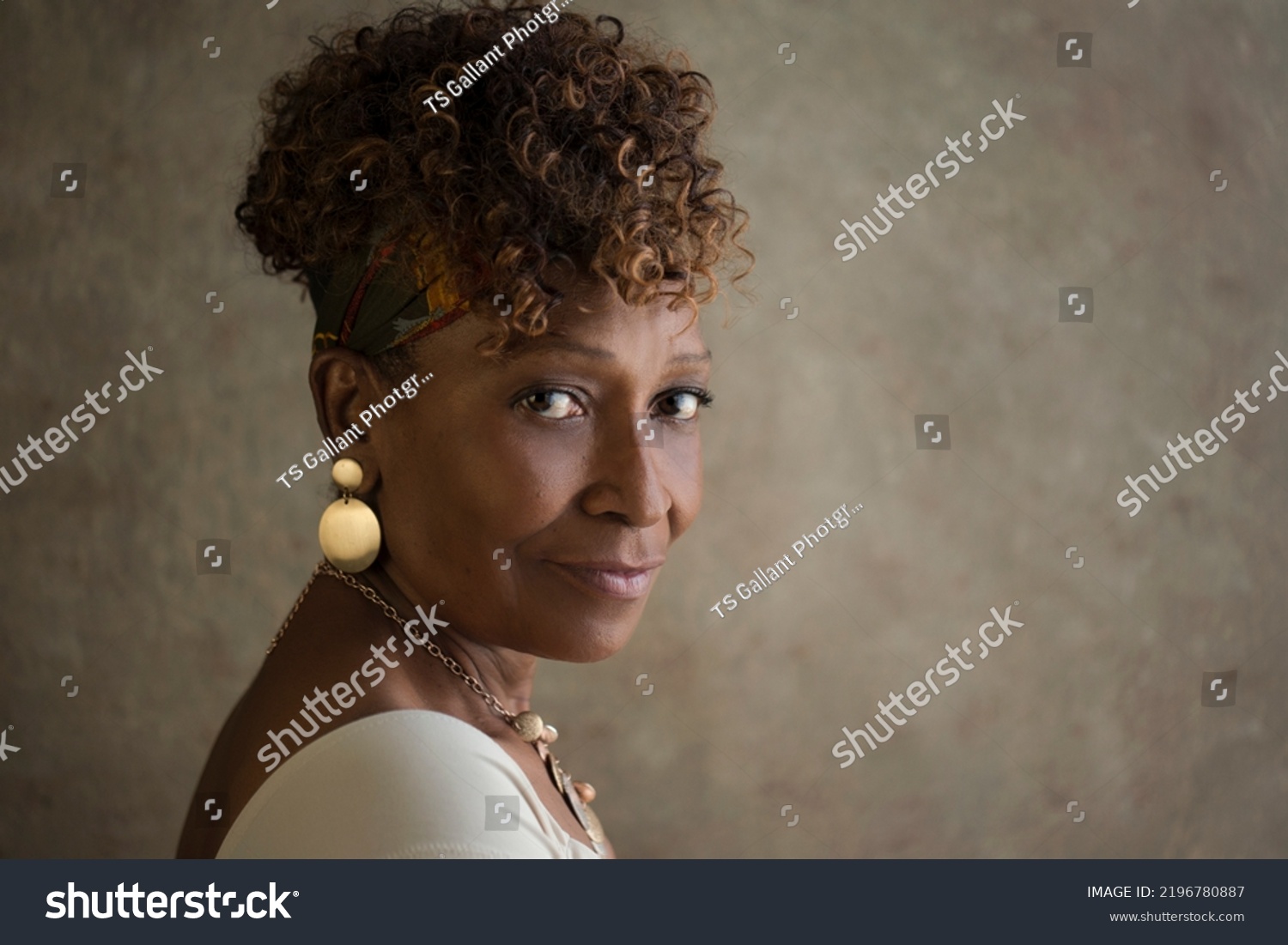 Portrait of a beautiful elderly 70-year-old African-American grandma spokesperson looking back over shoulder with ad or copy space for your ad #2196780887