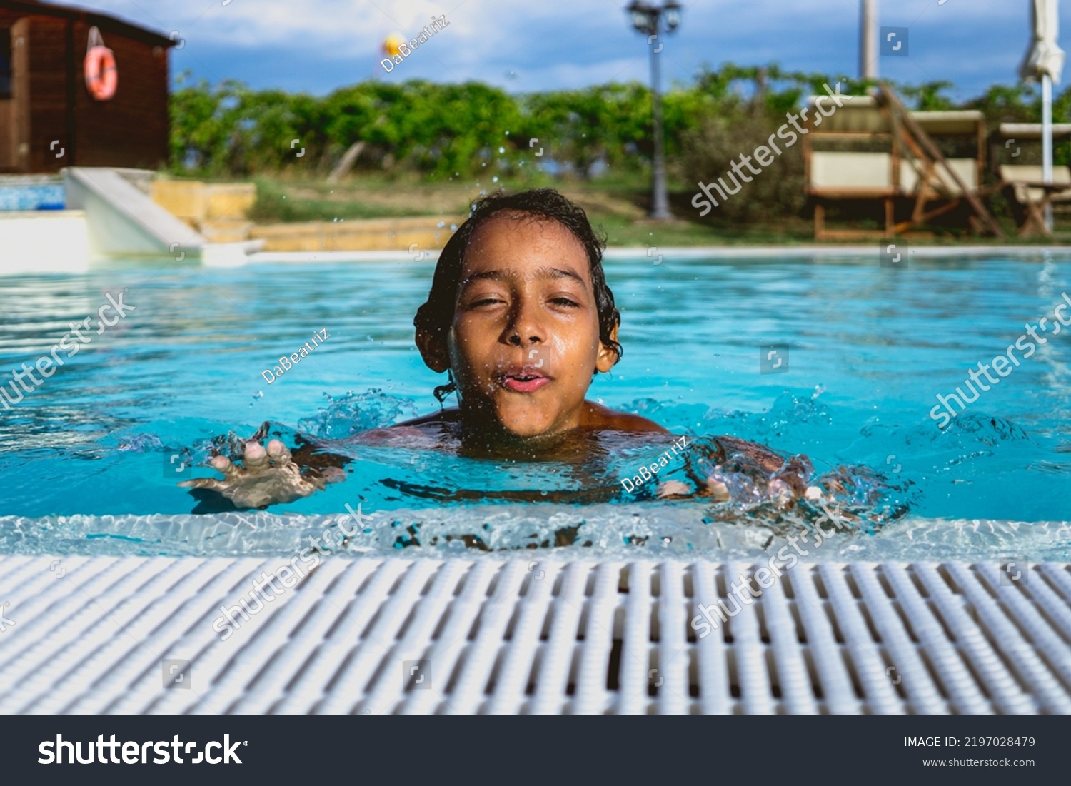 beautiful Hispanic boy playing in an outdoor pool #2197028479