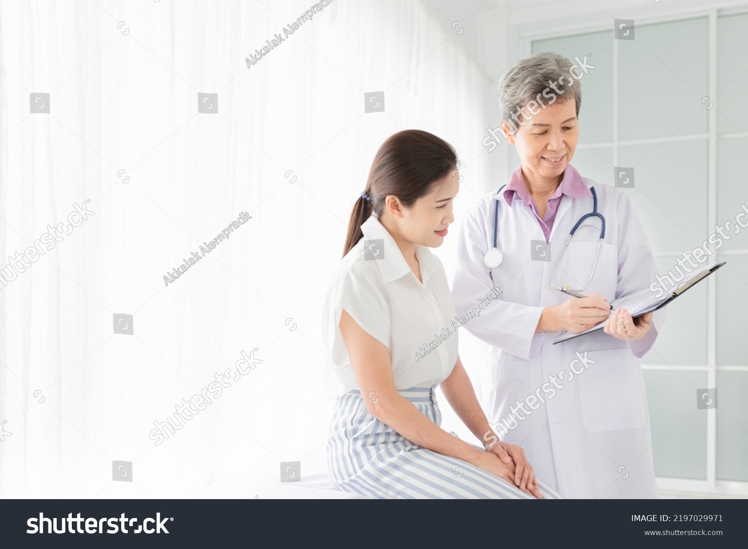 light and blur people, asian female patient talk with doctor in hospital,  doctor screening and write patient information on patient chart, healthcare promotion
 #2197029971