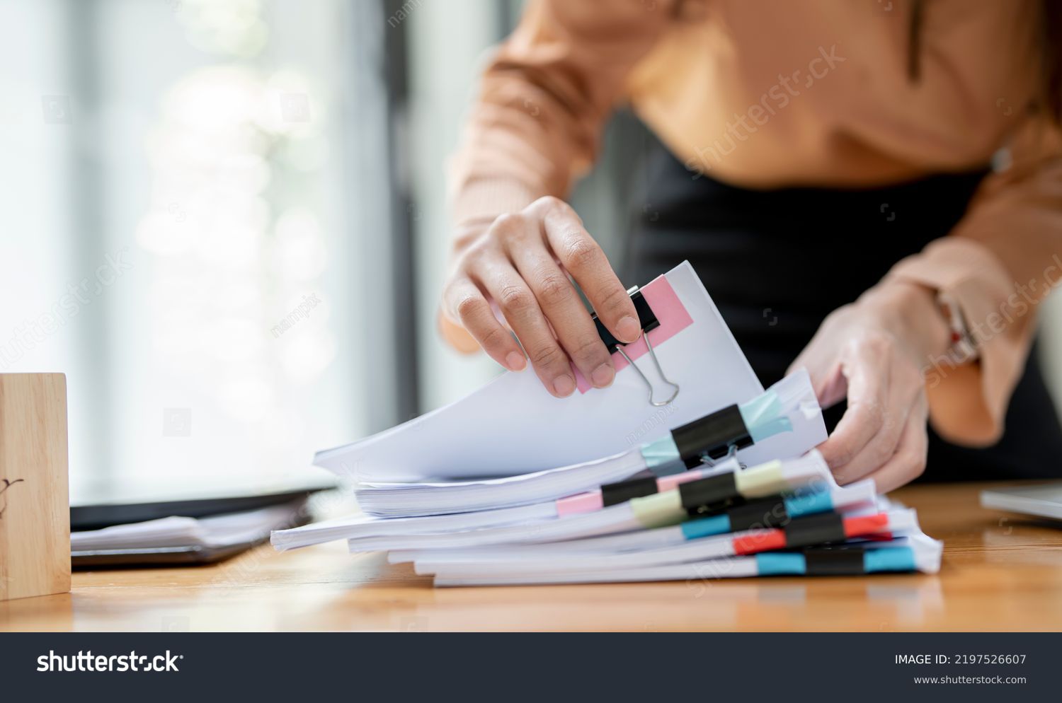 Businesswoman hands working in Stacks of paper files for searching and checking unfinished document achieves on folders papers at busy work desk office #2197526607