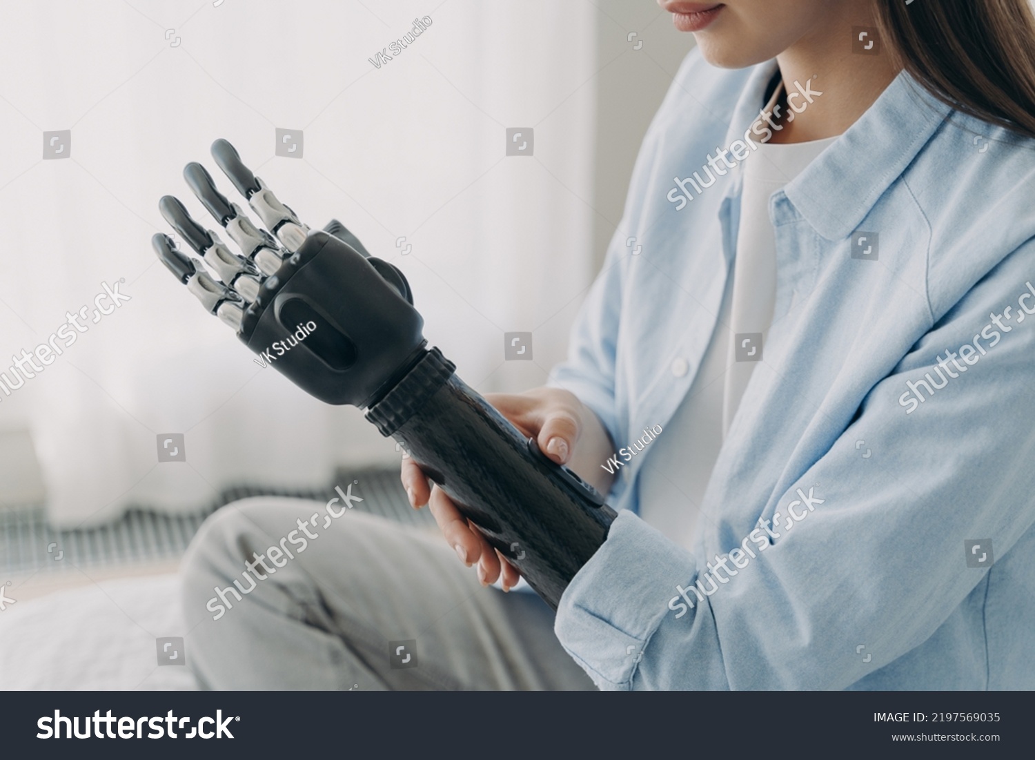 Women with disability customizing her sensory prosthetic arm, close-up. Female with disability using robotic prosthesis after limb loss. Application of bionic hands. Medical technologies. #2197569035