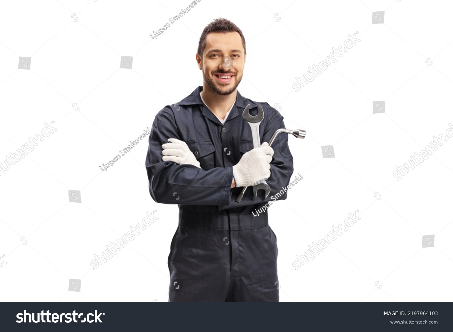 Car mechanic holding a wrench and a key tool isolated on white background #2197964103