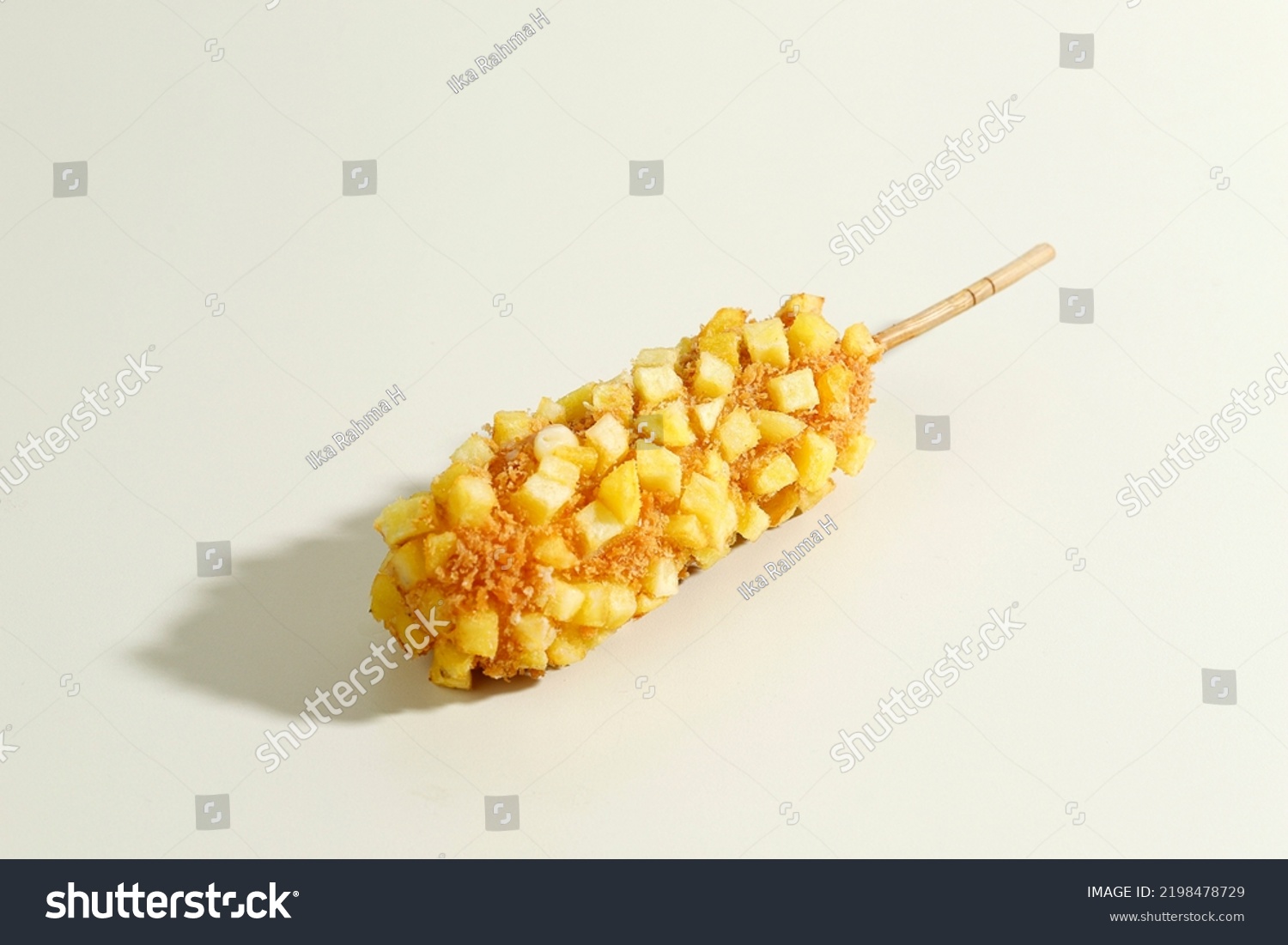 Delicious Crunchy Korean Style Chunky Potato Corn Dogs with Batter and Fried Potatoes. Isolated on Cream Background with Copy Space for Text #2198478729