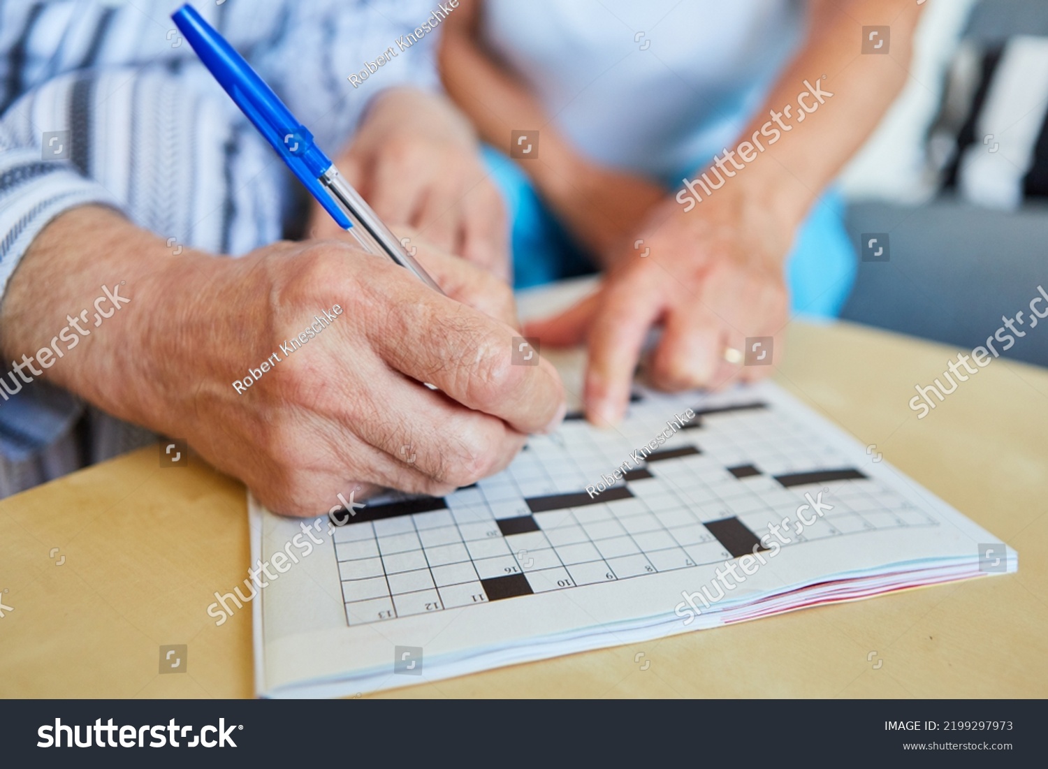 Two seniors do crossword puzzles at home or in a nursing home as memory training #2199297973
