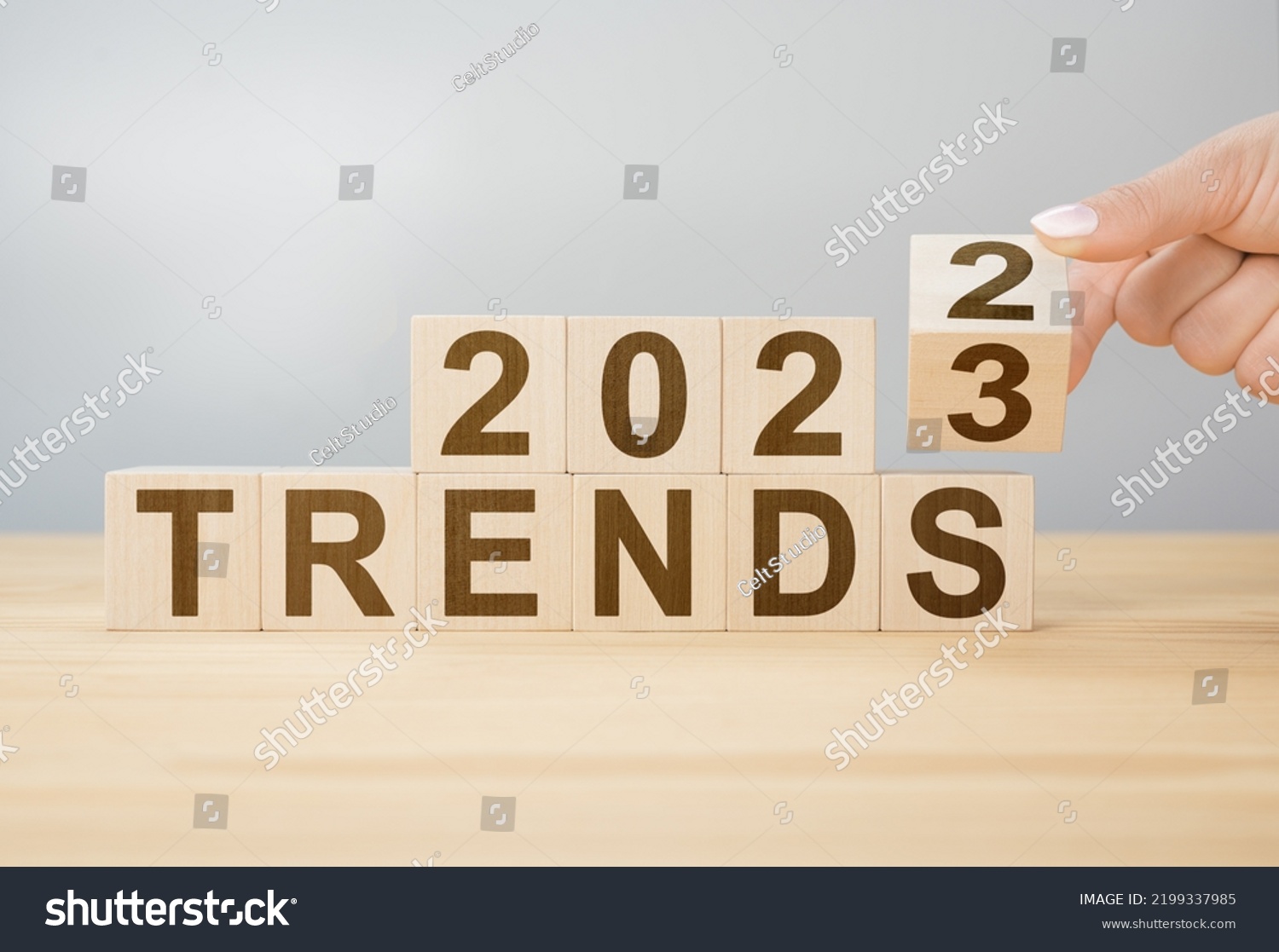 2023 trend concept. Hand flip wooden cube change year 2022 to 2023. gray background, copy space. 2022 trends concept. Hand flip wooden cube change on desk #2199337985