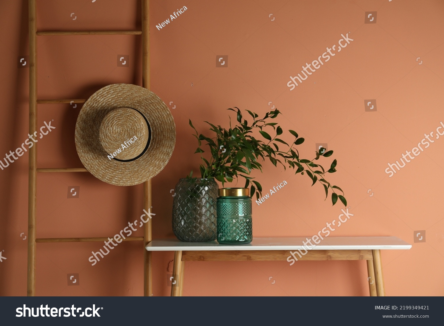 Stylish decorative vases on table near wall #2199349421