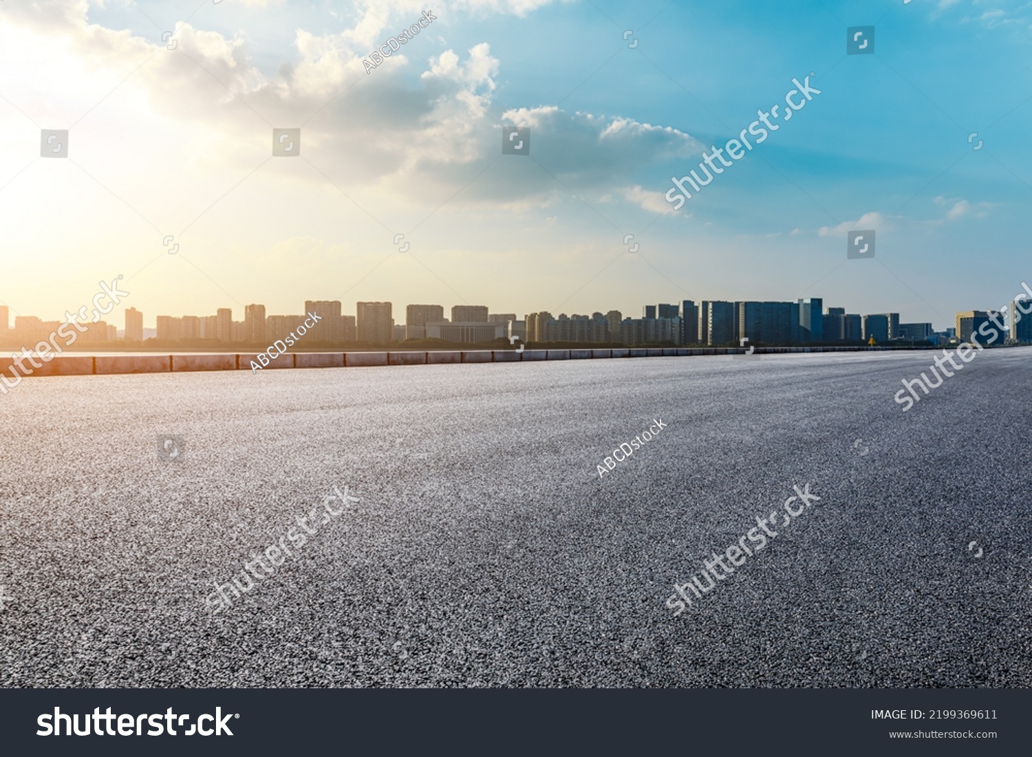 Asphalt road and modern city skyline with buildings scenery at sunset #2199369611