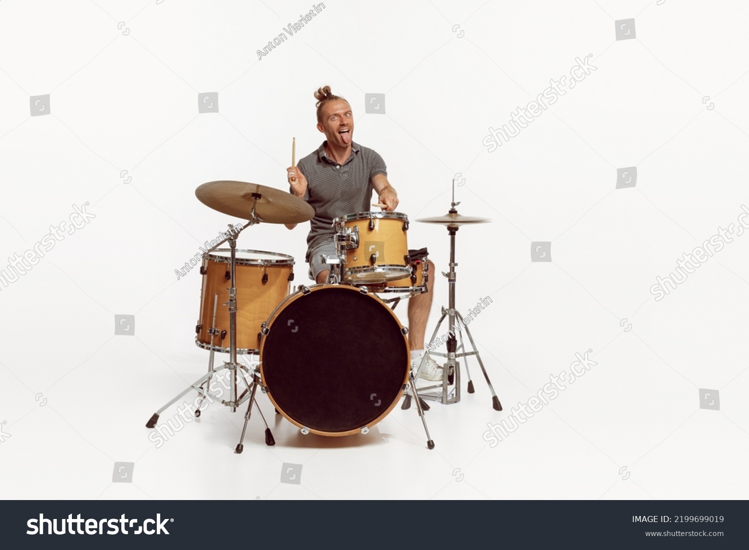 Portrait of funny emotive man playing drums, performing isolated over white background. Bass, rock music. Concept of live music, performance, retro style, creativity, artistic lifestyle #2199699019