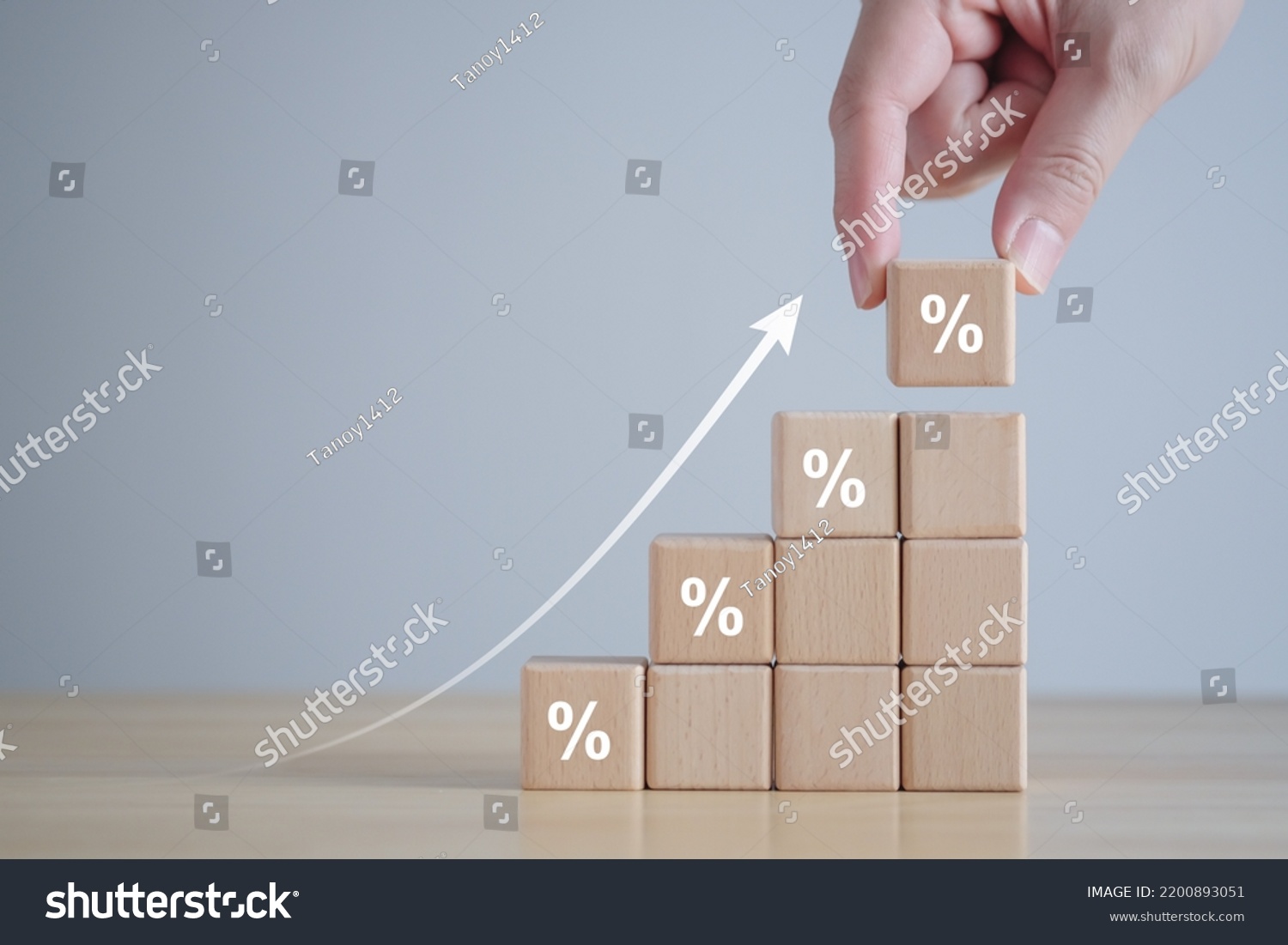 Interest rate finance and mortgage rates. hand holding wooden block with percentage sign and rise of arrow up, financial growth, interest rate increase, inflation, sale price and tax rise concept. #2200893051