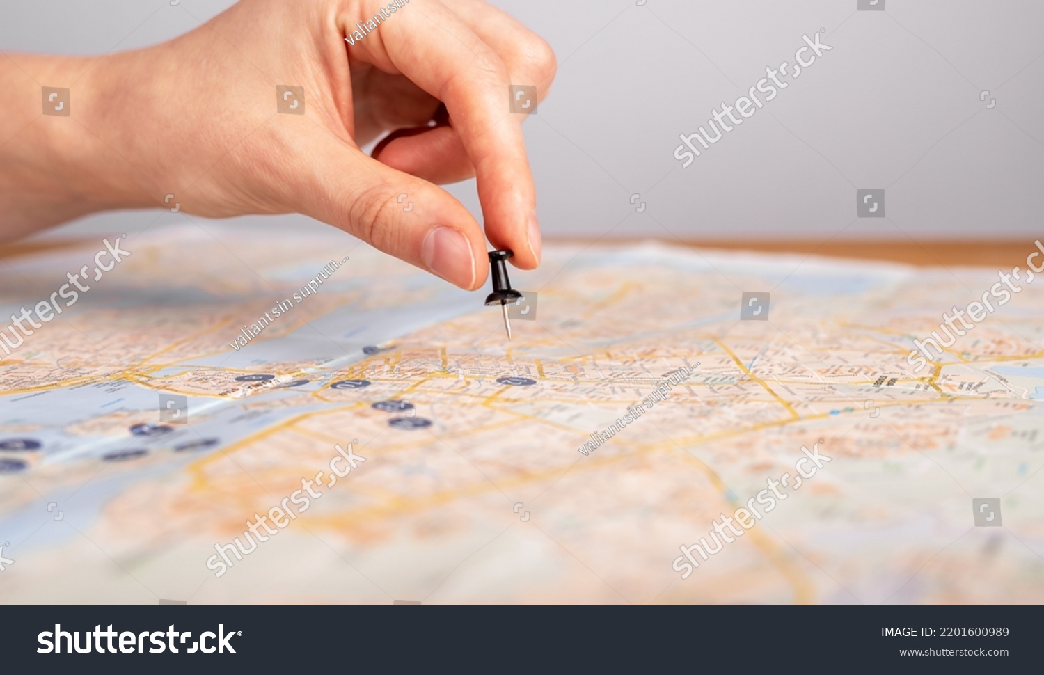 Woman hand pushing pin on map. Trip planning. Female marking travel destination, location with pushpin. Adventure, navigation, logistics concept. High quality photo #2201600989