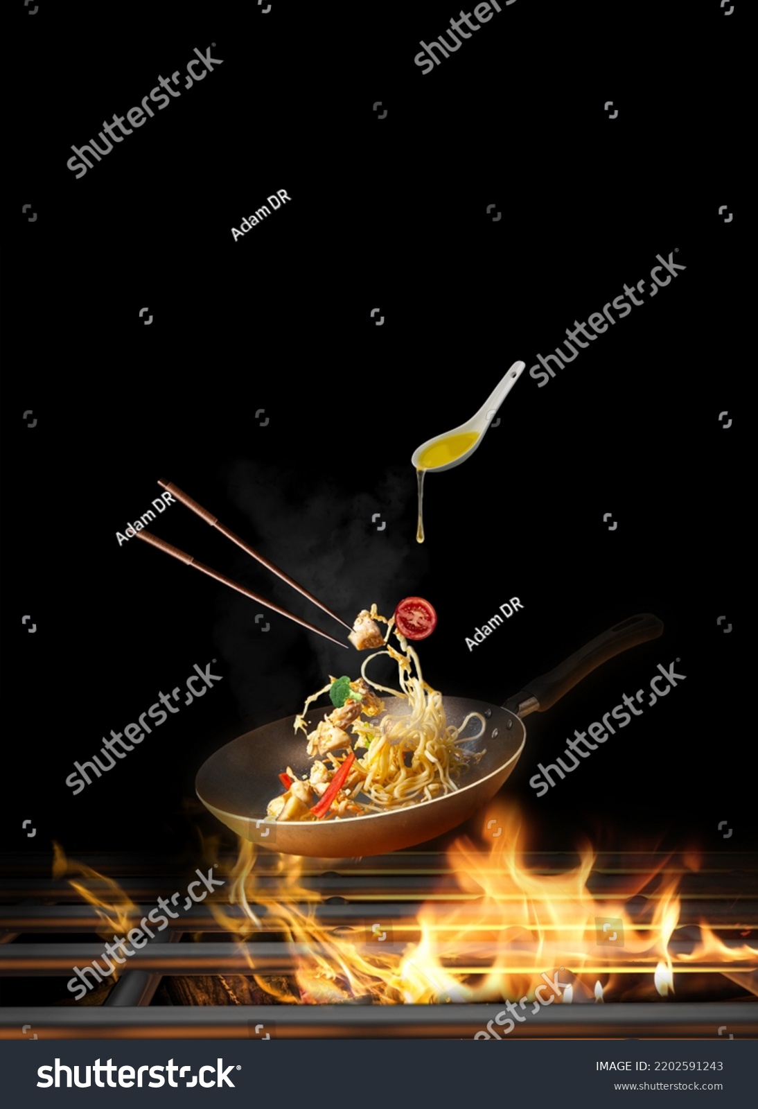 Flying Spaghetti with chicken and vegetables in a pan on fire - black background-Copy space #2202591243