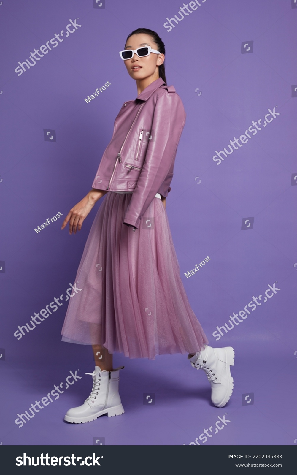 Fashion asian female model. Lilac leather jacket, lilac skirt, white boots, sunglasses. Asian fashion #2202945883