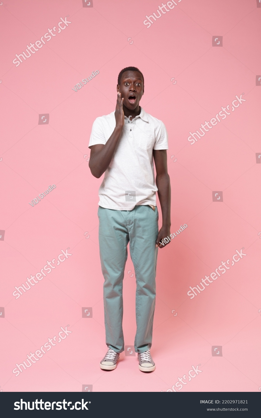 Full length vertical photo of shocked amazed surprised young man 20s he wear white shirt blue trousers put hand on cheek isolated on plain pastel light pink background studio. People lifestyle concept #2202971821