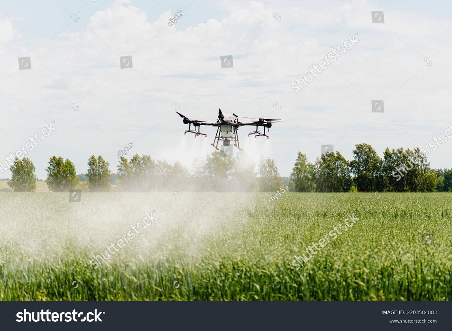 Modern technologies in agriculture. An industrial drone flies over a green field and sprays useful pesticides to increase productivity and destroys harmful insects. increase productivity #2203584883
