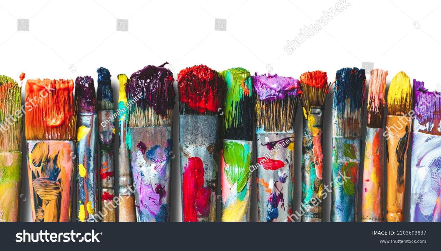 Row of artist paintbrushes closeup on white. Artistic brushes smeared with paints on white background. #2203693837