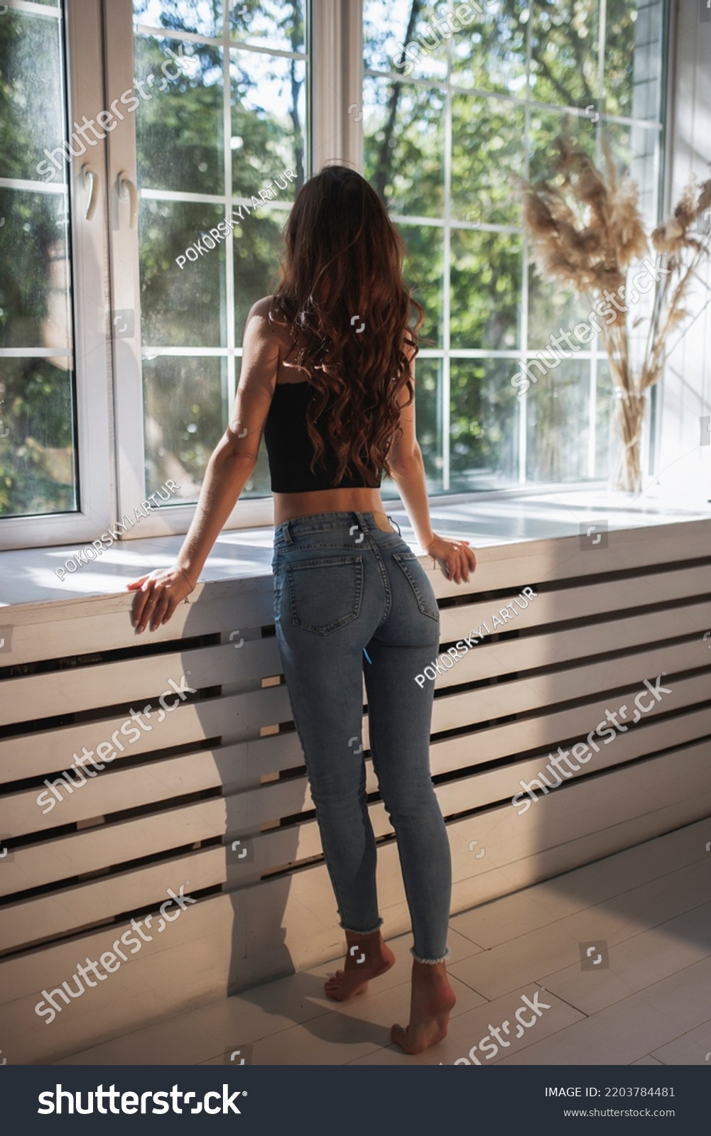 Girl in tight jeans look out the window
 #2203784481
