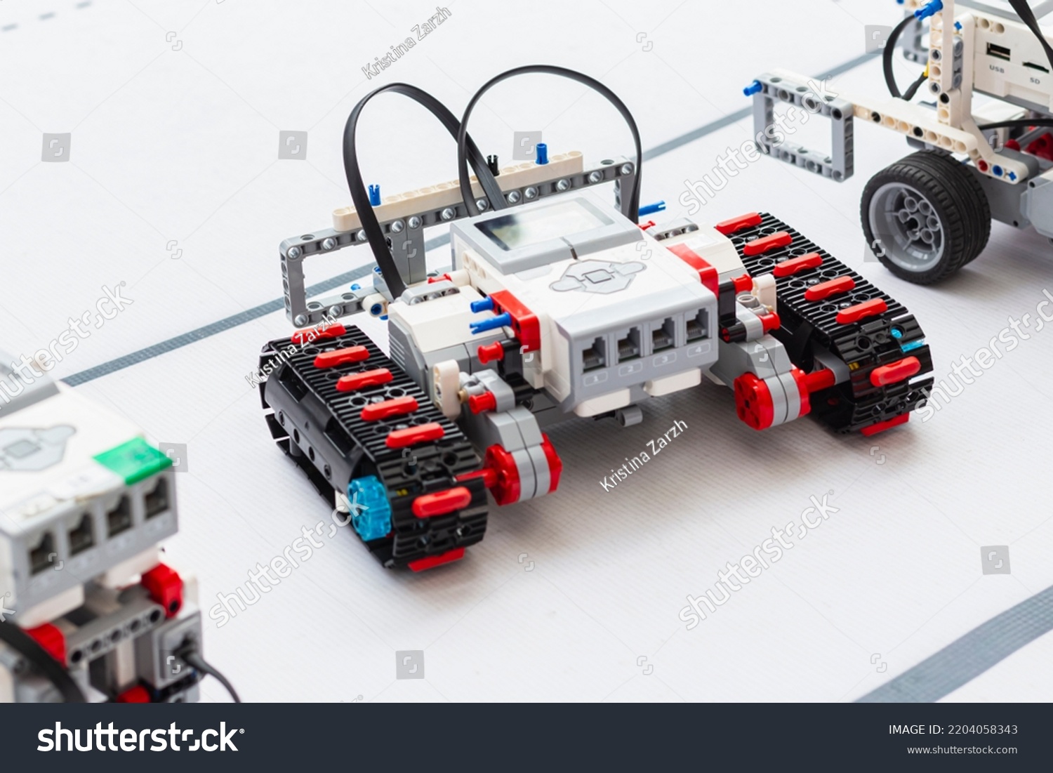 Building model RC robots concept. Caterpillar model of radio-controlled self-propelled vehicle.Radio control robot assembly on white desk. Professional toy RC models of robots. Natural lighting. #2204058343
