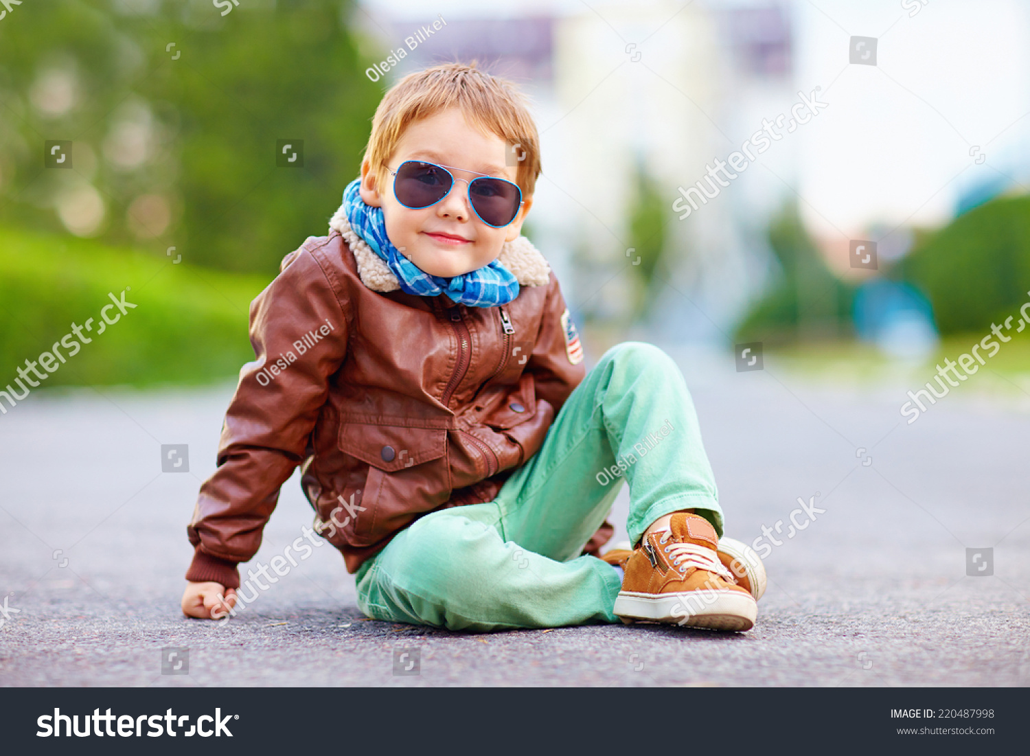 cute stylish boy in leather jacket sitting on the road #220487998