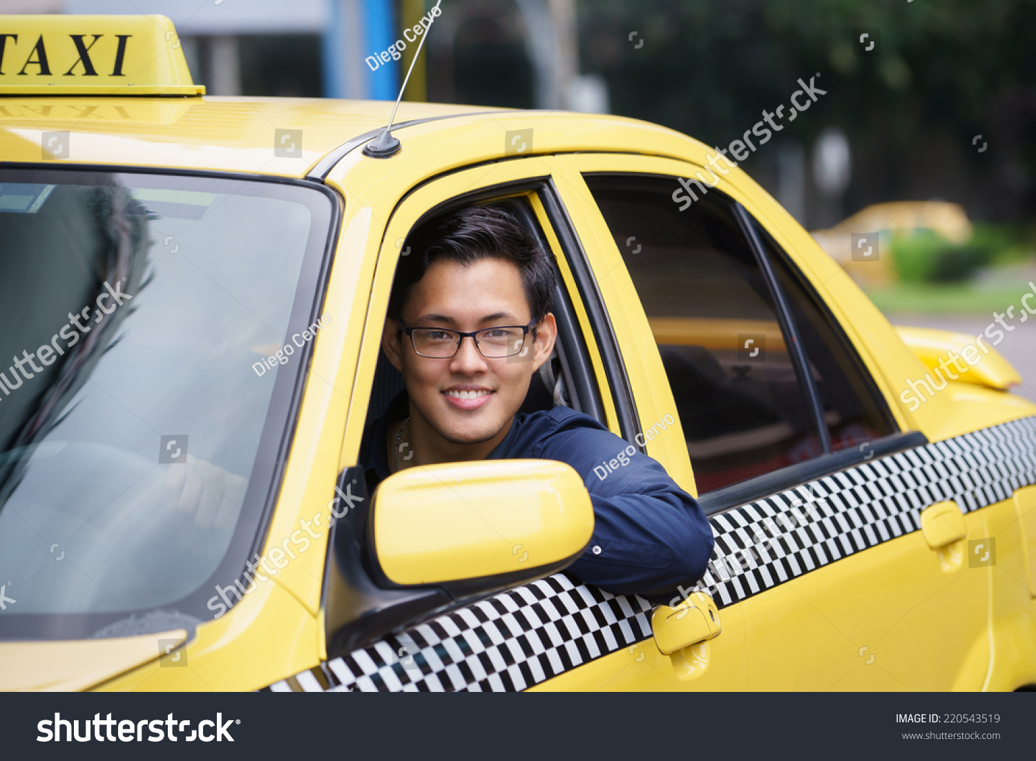 Portrait of happy chinese taxi driver in yellow car smiling and looking at camera #220543519