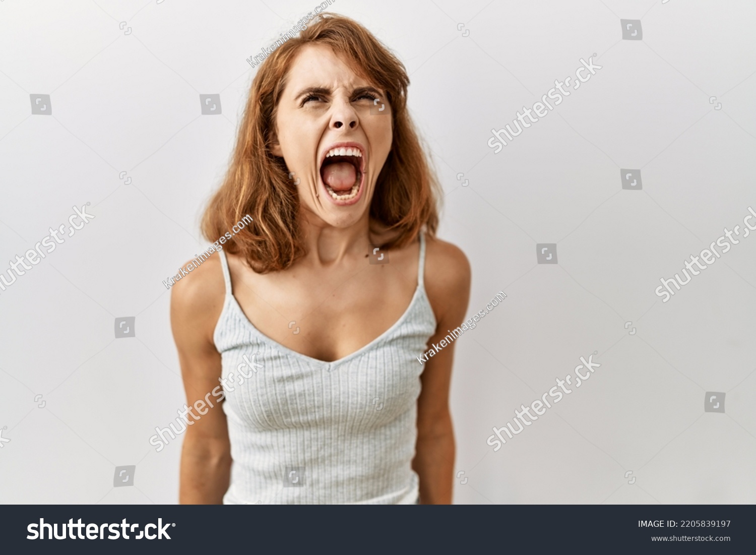Beautiful caucasian woman standing over isolated background angry and mad screaming frustrated and furious, shouting with anger. rage and aggressive concept.  #2205839197
