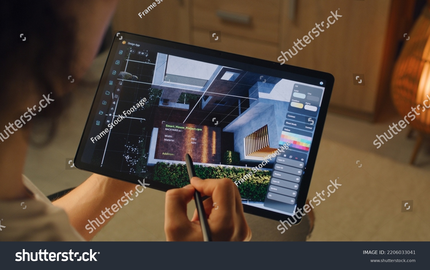 Male 3D designer having remote freelance project and working on smart house exterior in 3D modeling application using digital tablet computer and pencil #2206033041