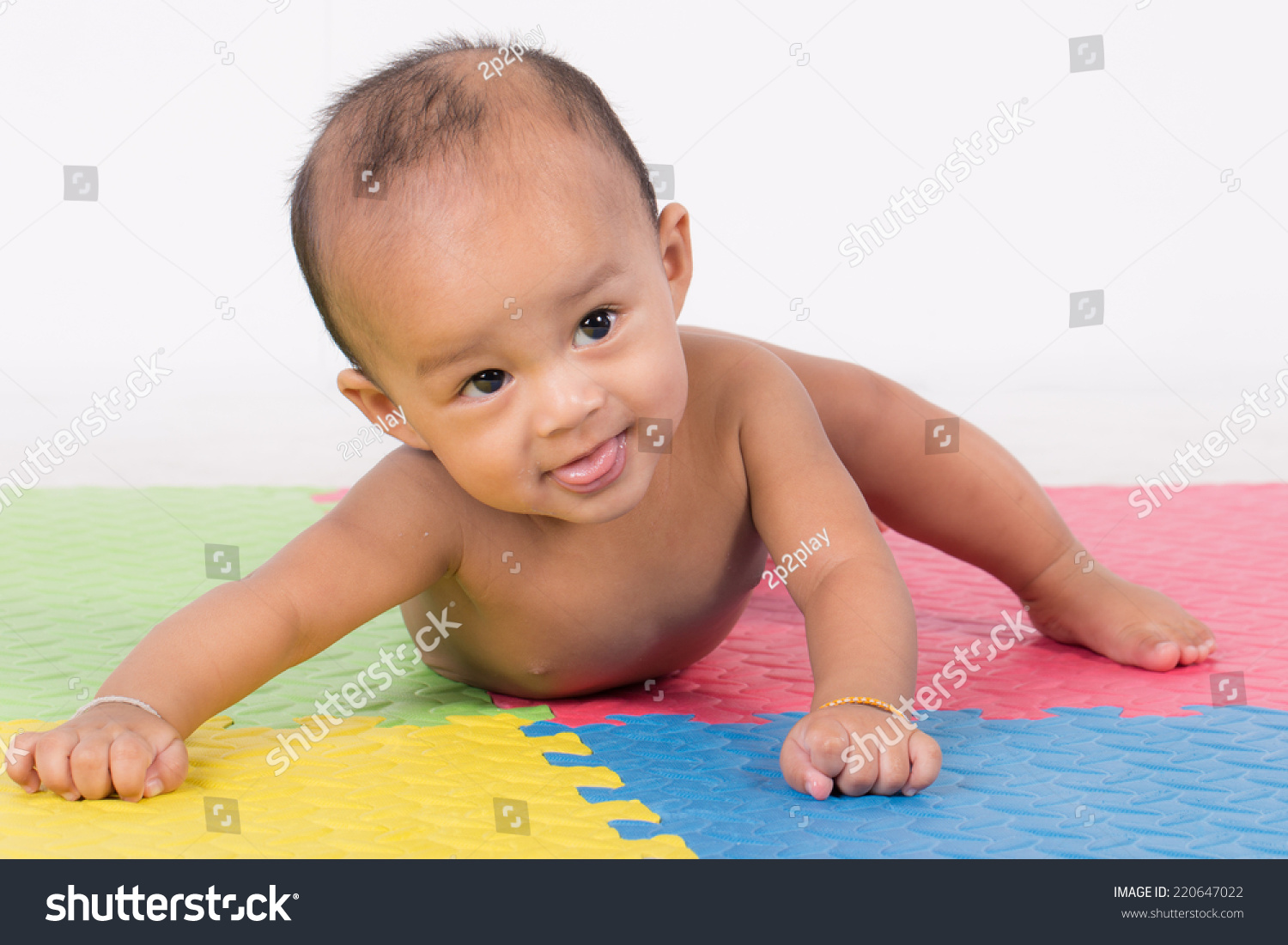 Happy cute 5 month old Asian baby boy with short black hair on rubber floor #220647022