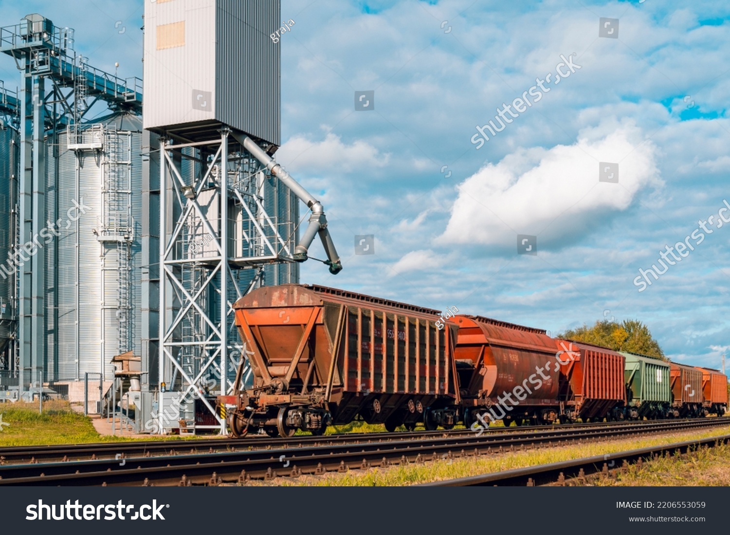 Loading railway carriages with grain at grain elevator. Grain silo, warehouse or depository is an important part of harvesting #2206553059