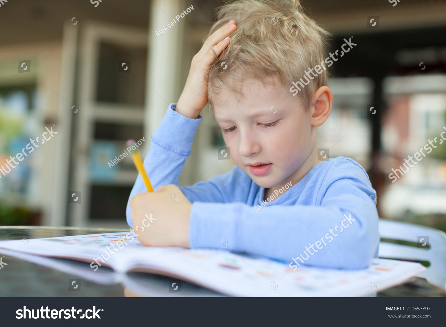concentrated little boy doing homework #220657897