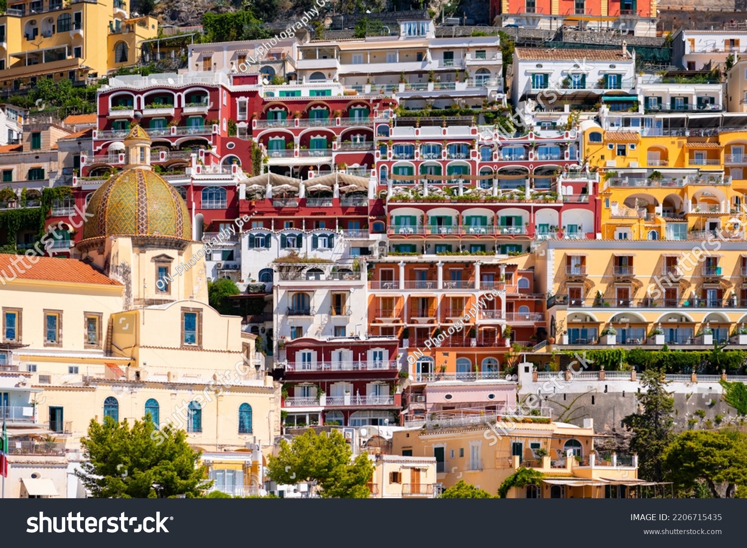 Positano on the famous Amalfi Coast in Campania Italy. Picturesque historic village with colorful houses and church built on the steep coastline. Summer atmosphere in popular tourist destination.  #2206715435
